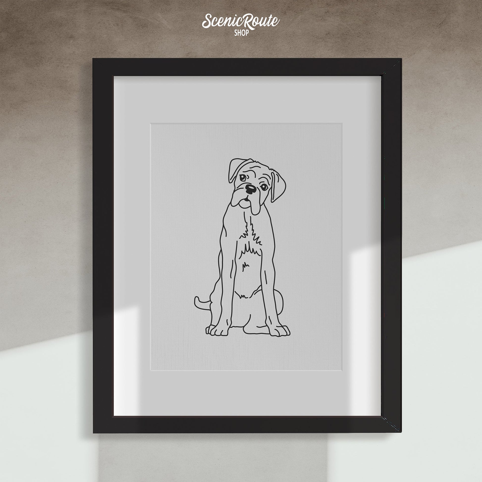 A framed line art drawing of a Boxer dog on a white wall