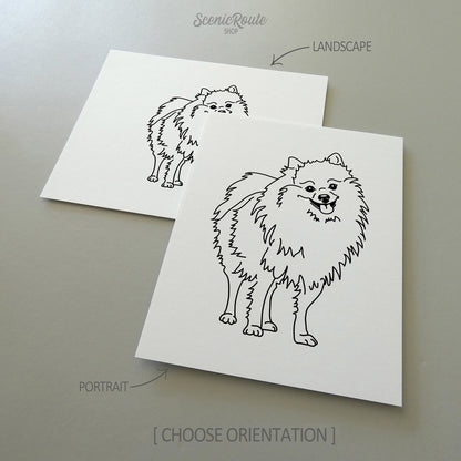 Two line art drawings of a Pomeranian dog on white linen paper with a gray background.  The pieces are shown in portrait and landscape orientation for the available art print options.