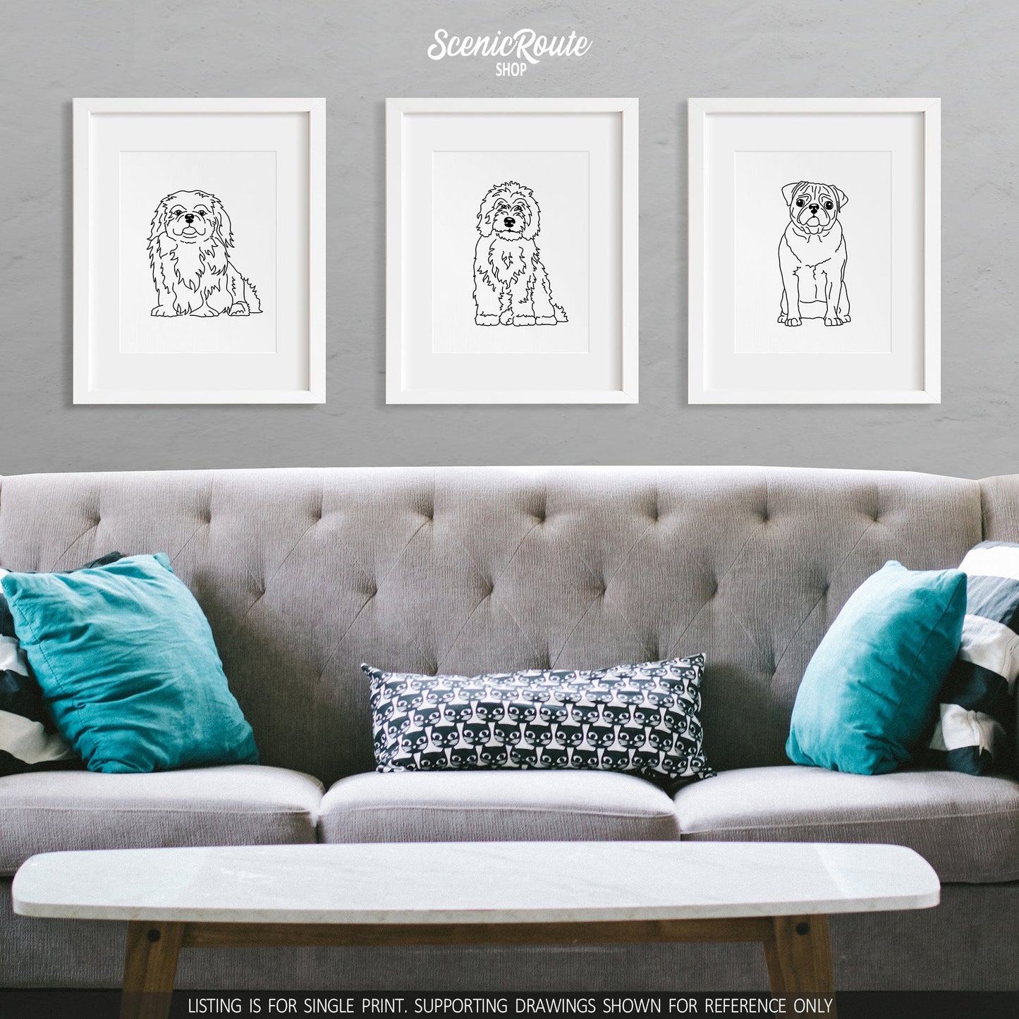 A group of three framed drawings on a gray wall above a couch. The line art drawings include a Pekingese dog, a Sheepadoodle dog, and a Pug dog