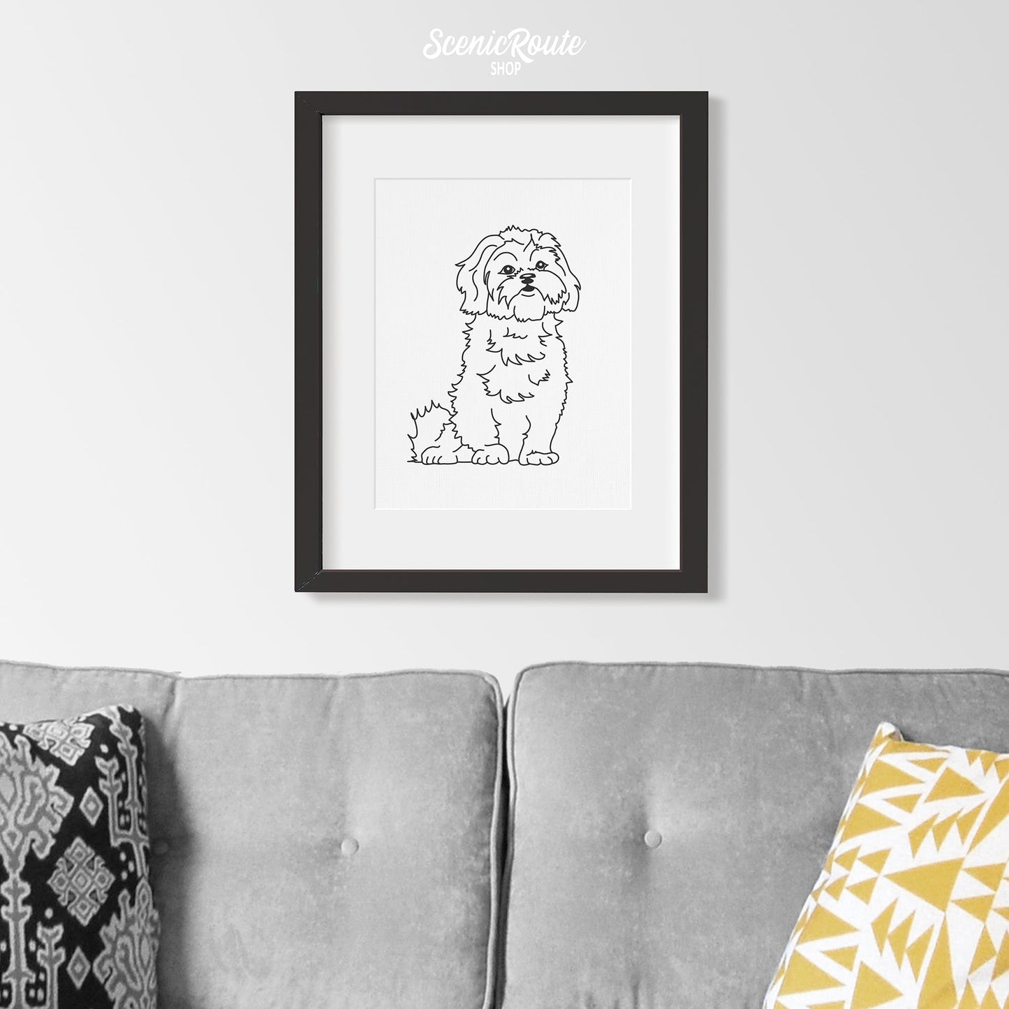 A framed line art drawing of a Shih Tzu dog hung above a couch