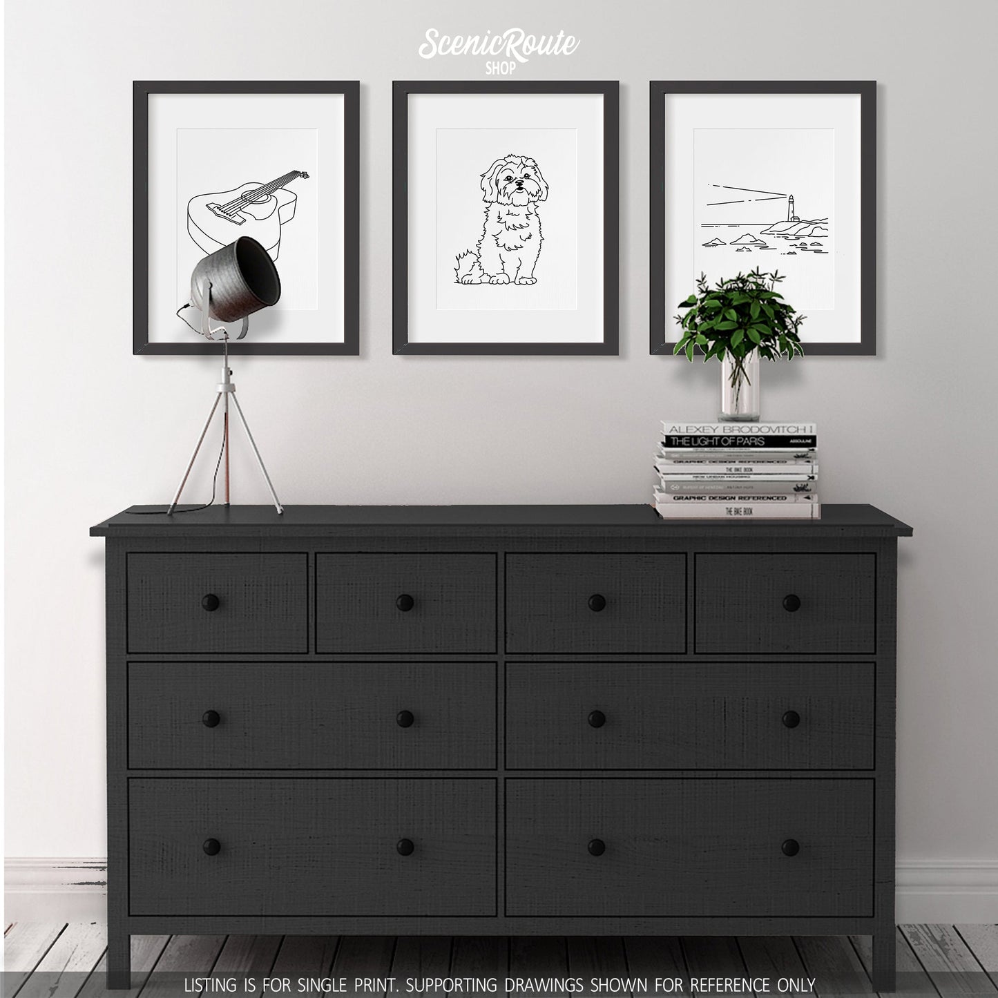 A group of three framed drawings on a white wall above a black dresser. The line art drawings include a Guitar, a Shih Tzu dog, and a Lighthouse