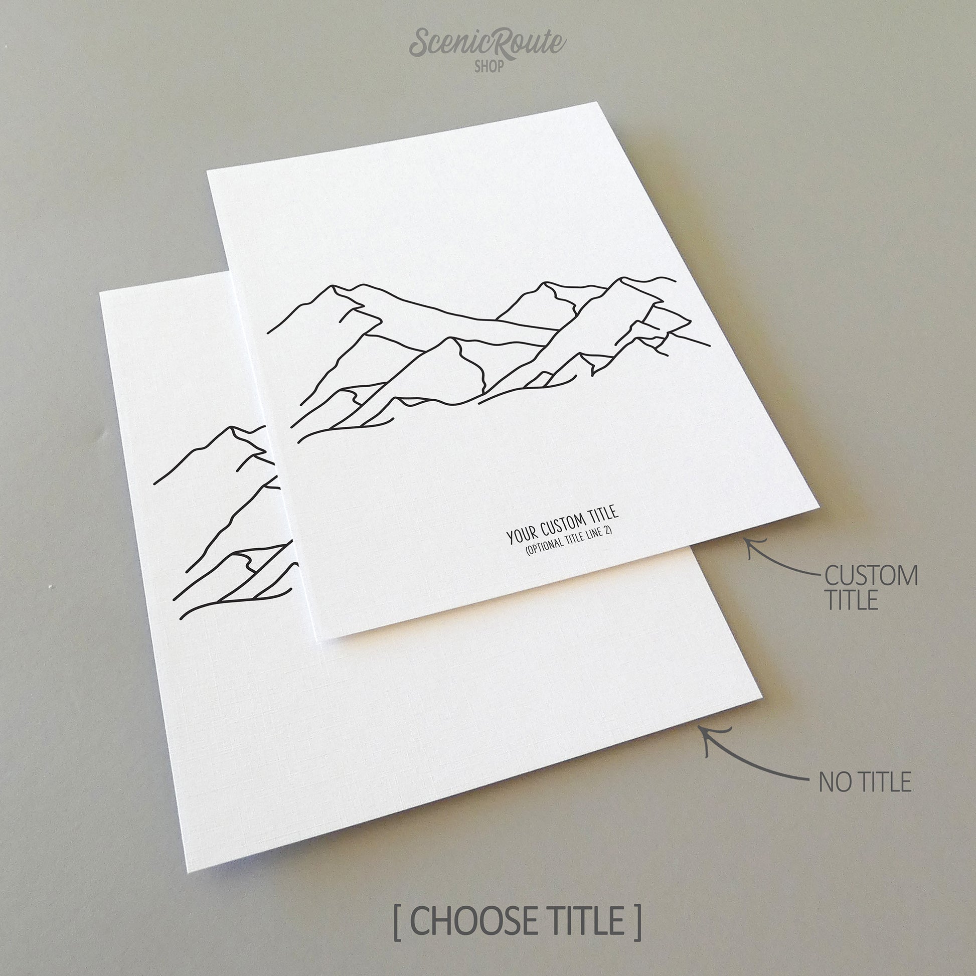 Two line art drawings of a mountain range on white linen paper with a gray background.  The pieces are shown with “No Title” and “Custom Title” options for the available art print options.