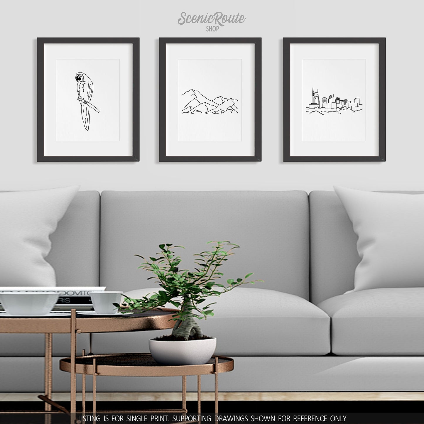A group of three framed drawings on a wall above a couch. The line art drawings include a Parrot, a Mountain Range, and the Nashville Skyline