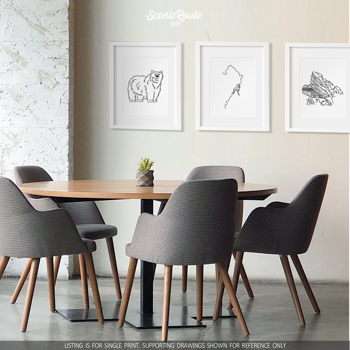 A group of three framed drawings above a dining table. The line art drawings include a Grizzly Bear, Rock Climbing, and Red Rocks Amphitheatre