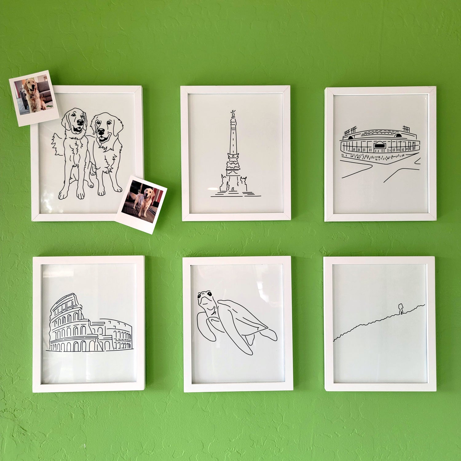 A group of six framed drawings on a green wall.  The line art drawings include two Golden Retrievers, the Soldiers and Sailors Monument, Wrigley Field, the Colosseum, a Sea Turtle, and a person Hiking