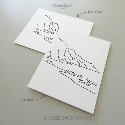 Two line art drawings of The NaPali Coast on white linen paper with a gray background.  The pieces are shown in portrait and landscape orientation for the available art print options.