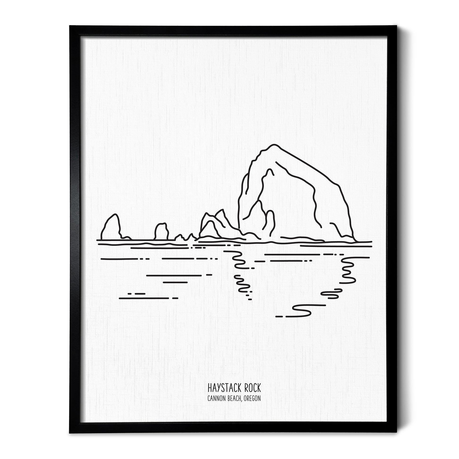 A line art drawing of Haystack Rock in Oregon on white linen paper in a thin black picture frame