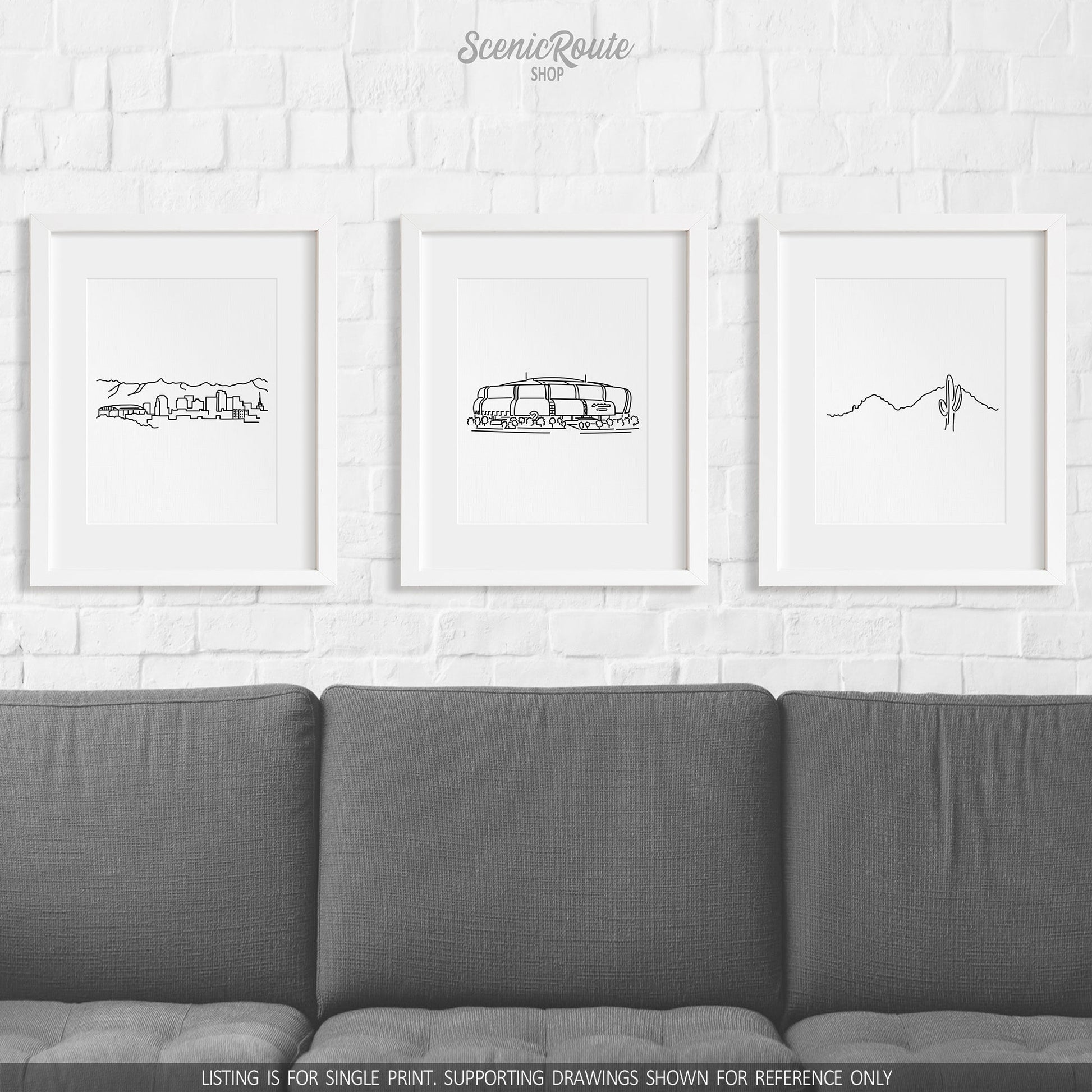 A group of three framed drawings on a wall above a couch. The line art drawings include the Phoenix Skyline, Cardinals Stadium, and Camelback Mountain