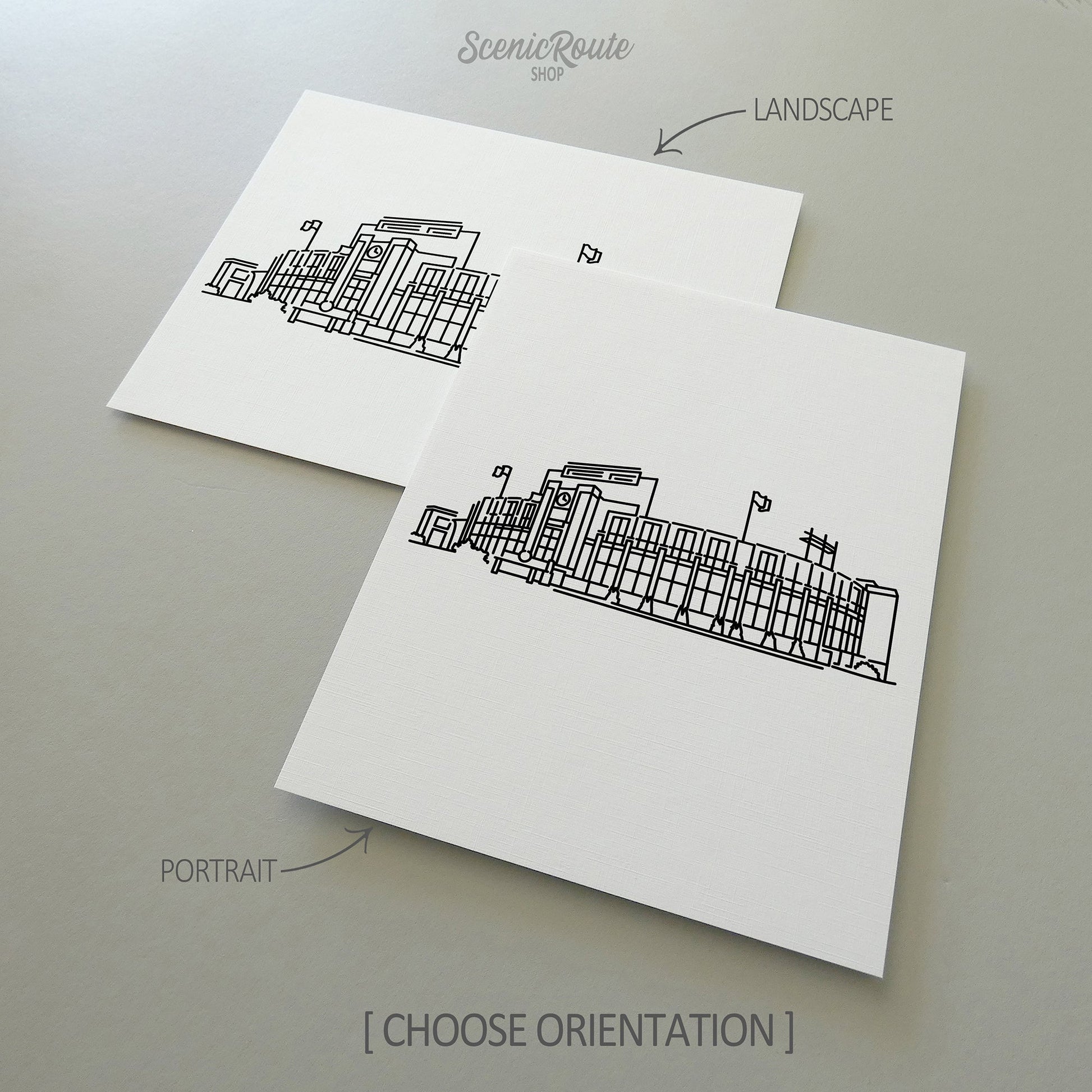 Two line art drawings of Lambeau Field on white linen paper with a gray background.  The pieces are shown in portrait and landscape orientation for the available art print options.
