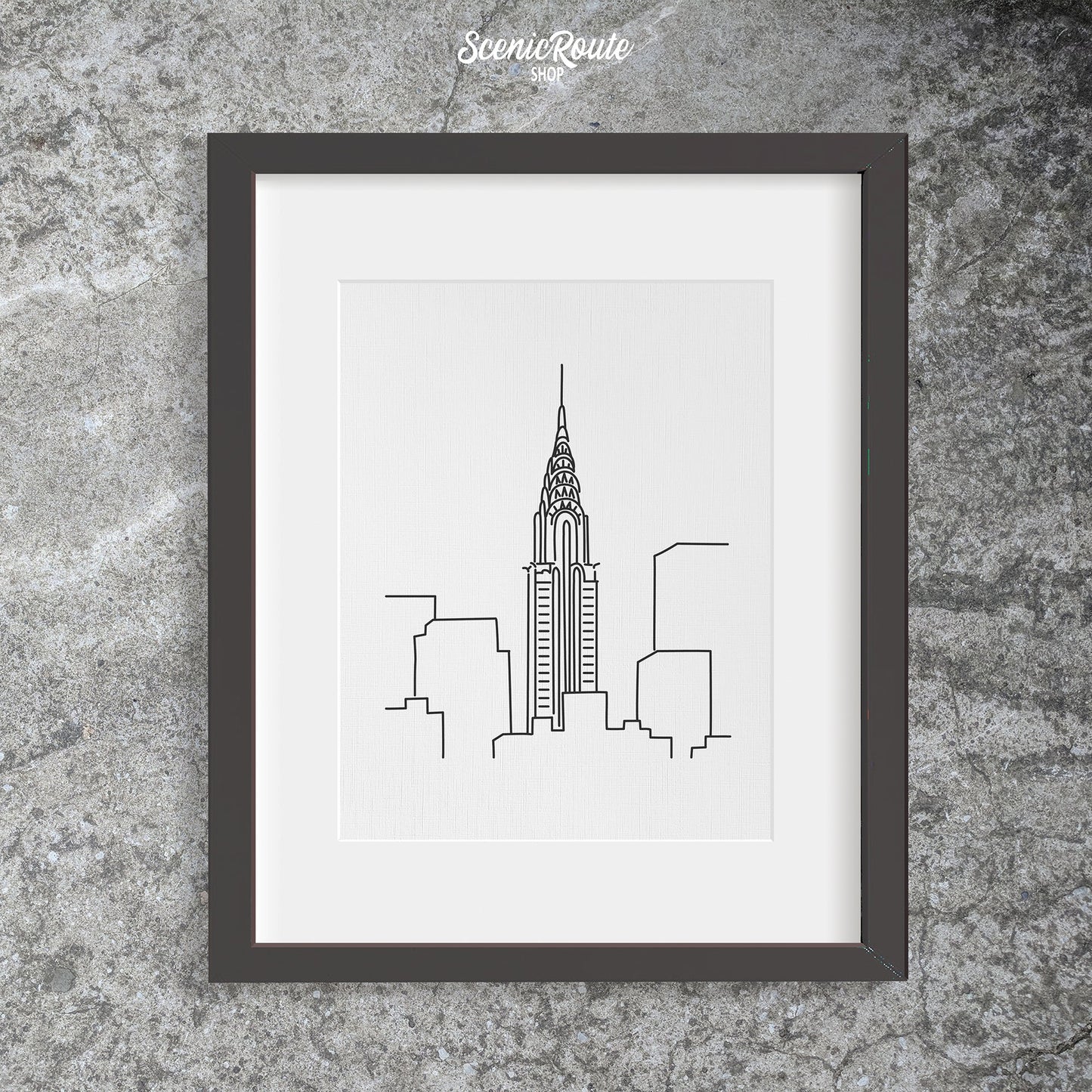 A framed line art drawing of the Chrysler Building