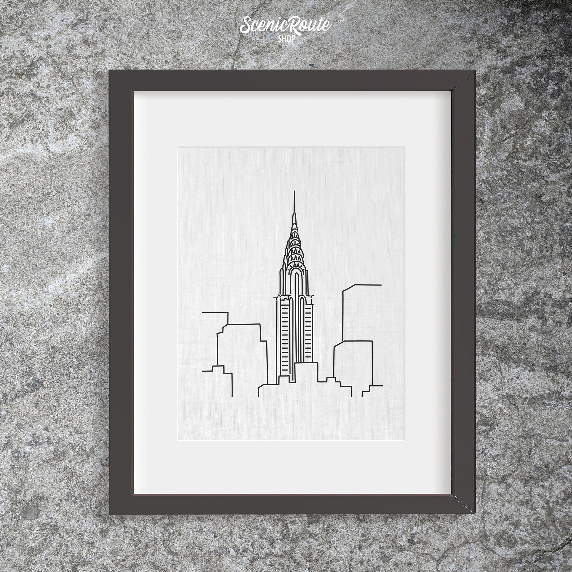 A framed line art drawing of the Chrysler Building