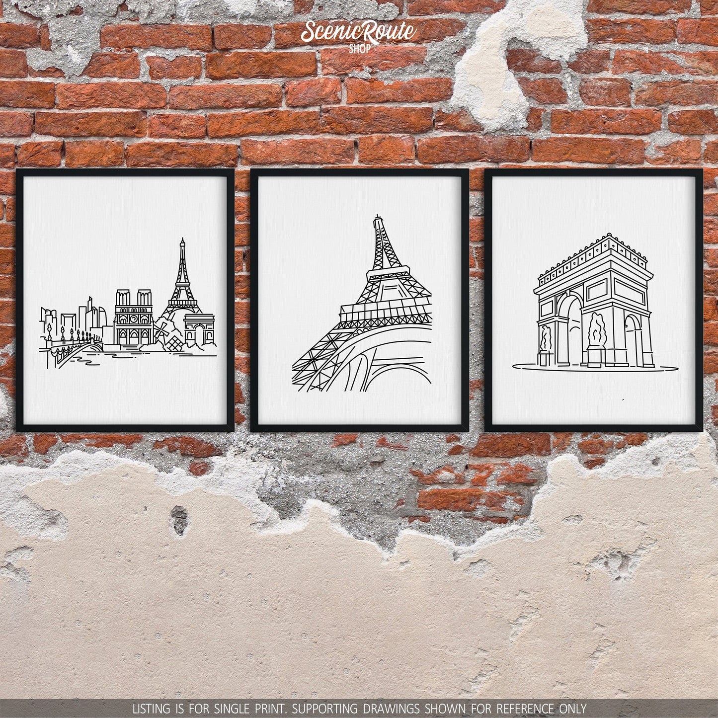 A group of three framed drawings on a brick wall. The line art drawings include the Paris Skyline, Eiffel Tower, and Arc de Triomphe