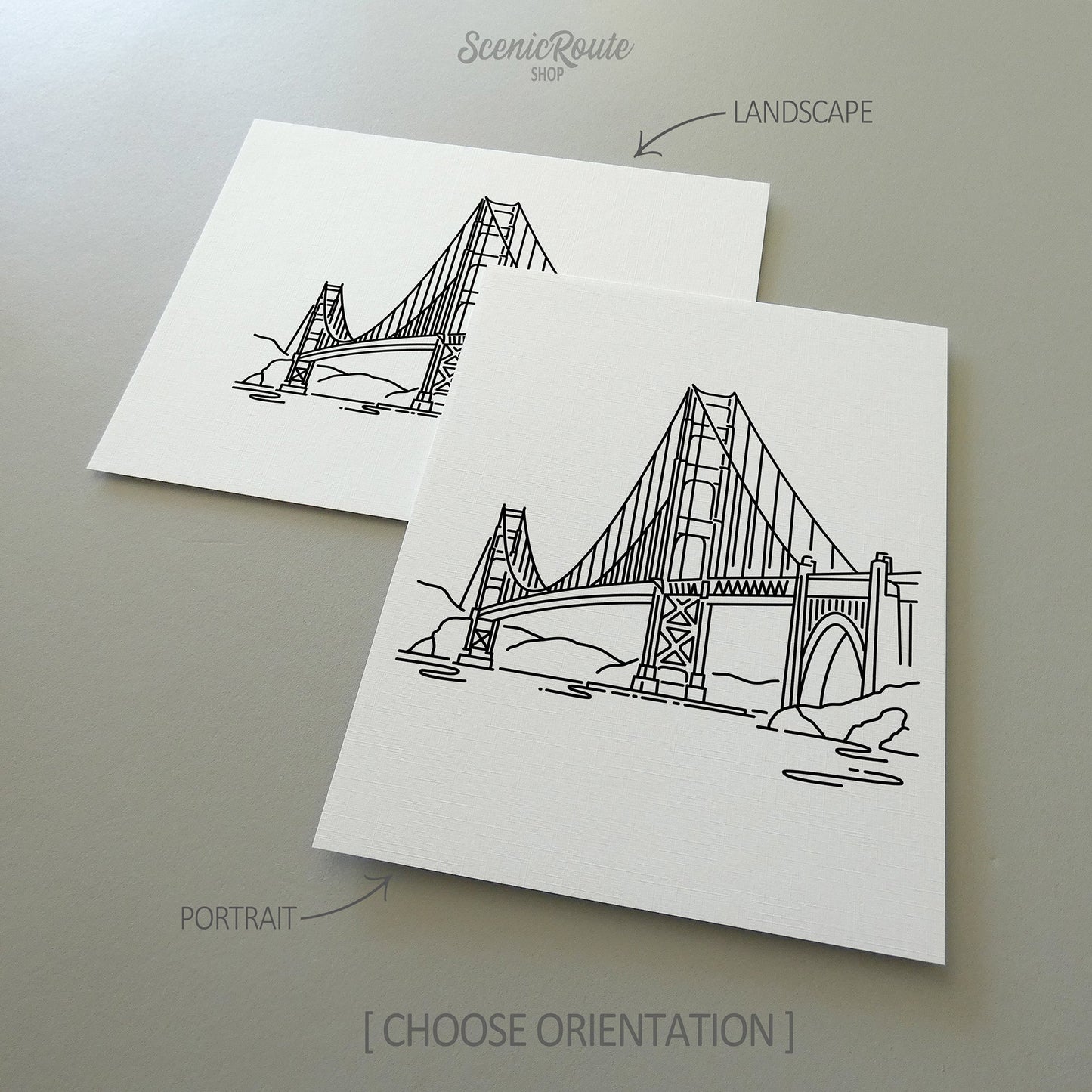 Two line art drawings of the Golden Gate Bridge on white linen paper with a gray background.  The pieces are shown in portrait and landscape orientation for the available art print options.