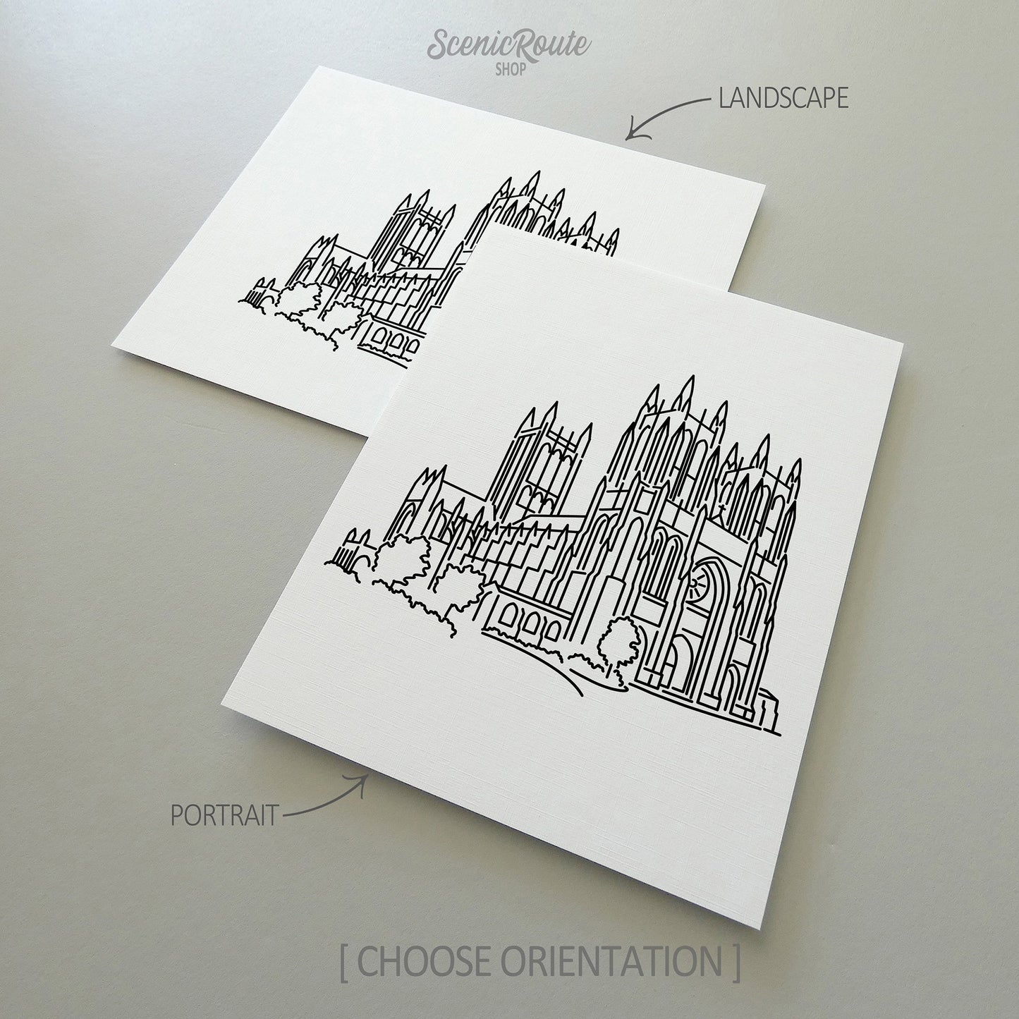 Two line art drawings of the National Cathedral on white linen paper with a gray background.  The pieces are shown in portrait and landscape orientation for the available art print options.