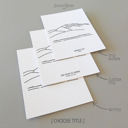 Three line art drawings of Humphrey's Peak in Arizona on white linen paper with a gray background.  The pieces are shown with title options that can be chosen and personalized.