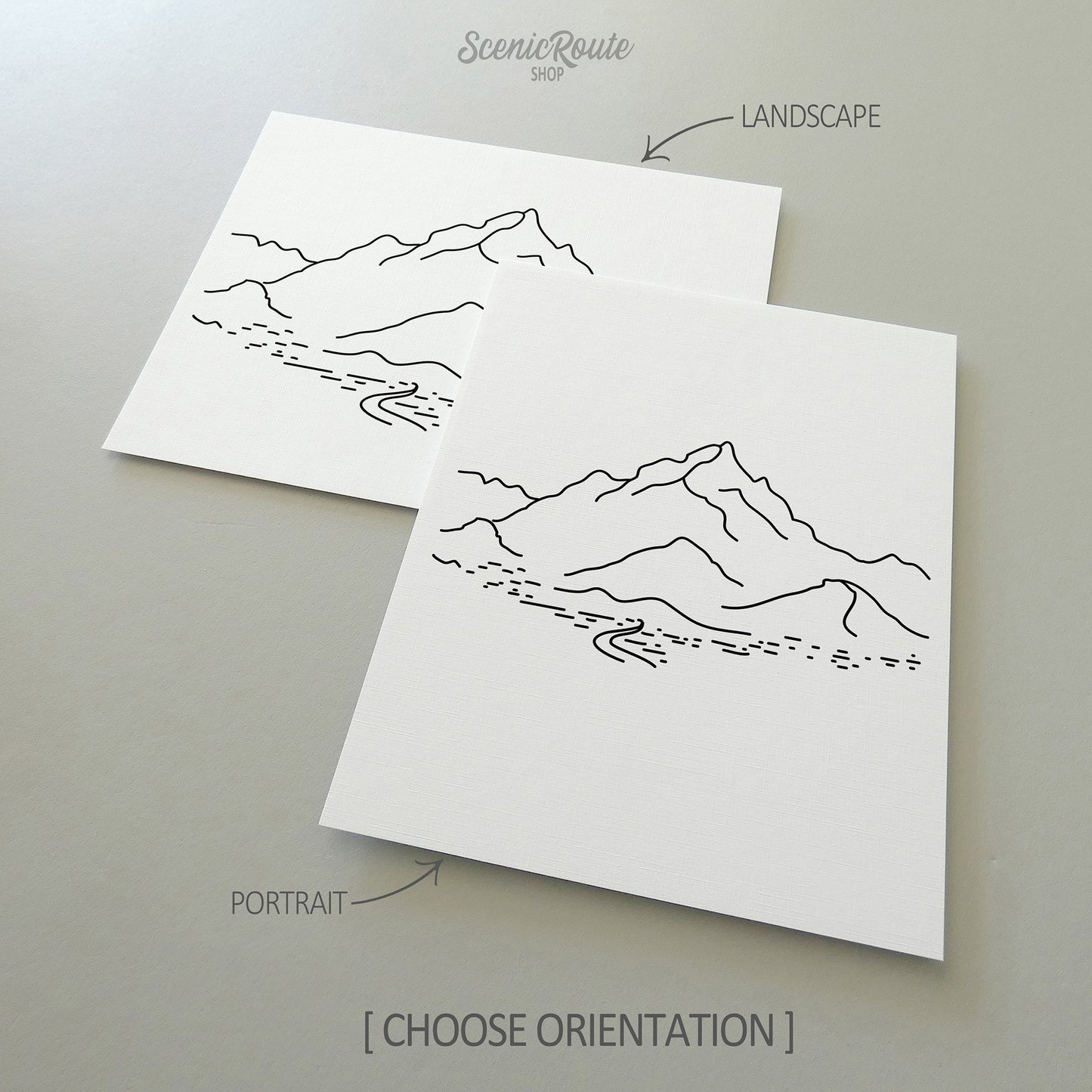 Two line art drawings of Piestewa Peak on white linen paper with a gray background.  The pieces are shown in portrait and landscape orientation for the available art print options.
