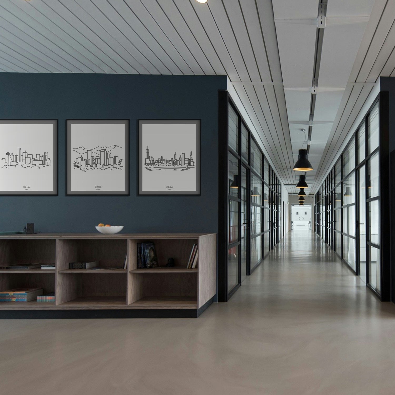 A group of three framed drawings in a modern office