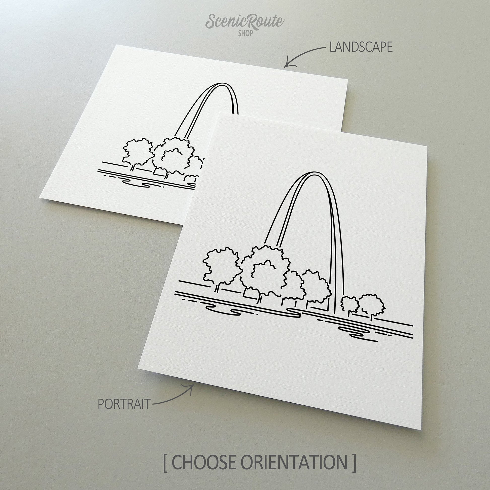 Two line art drawings of Gateway Arch National Park on white linen paper with a gray background.  The pieces are shown in portrait and landscape orientation for the available art print options.