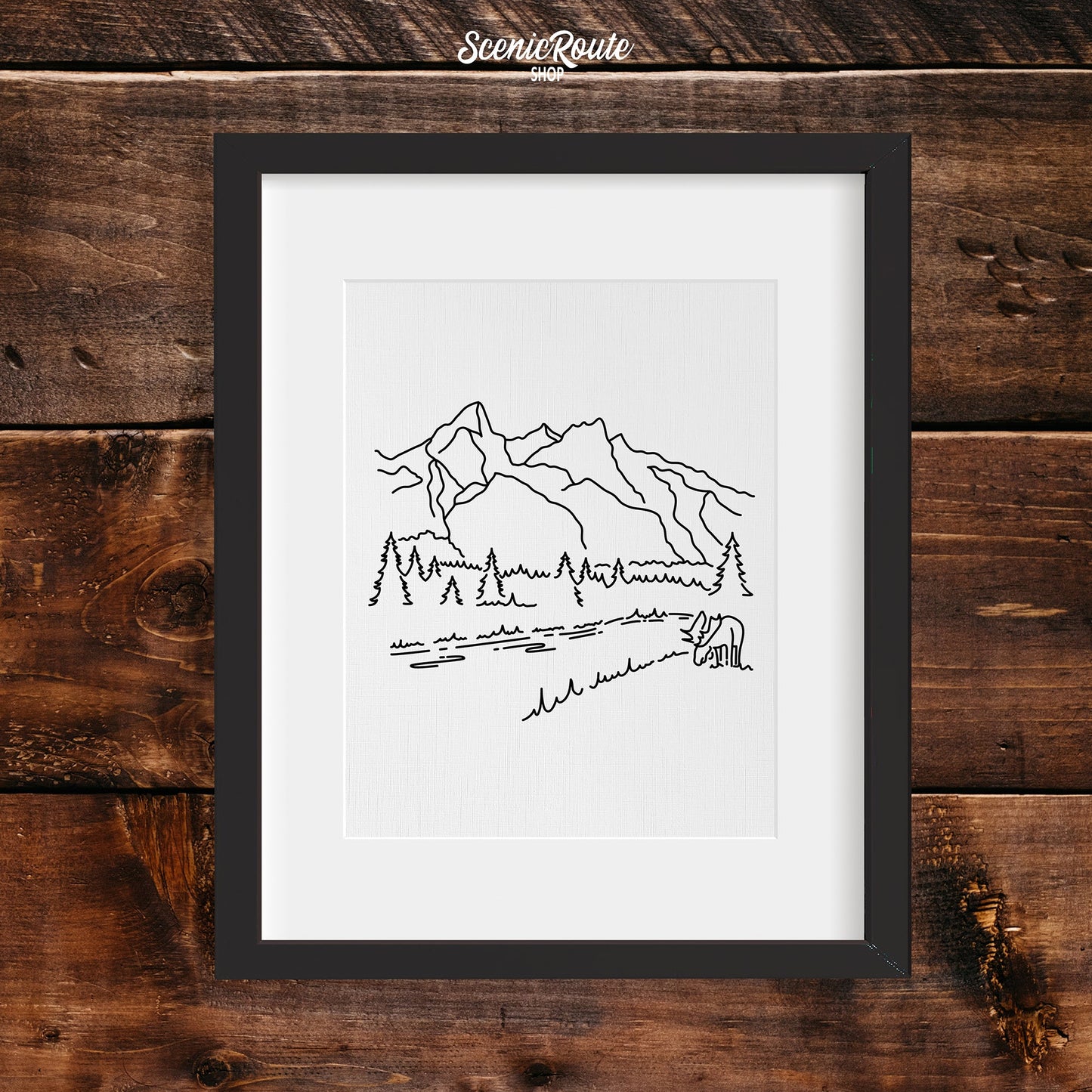 A framed line art drawing of Grand Teton National Park on a wood wall
