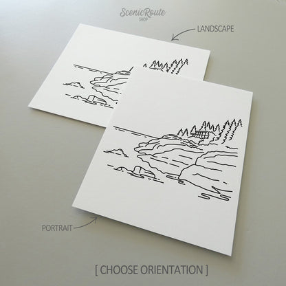Two line art drawings of Isle Royale National Park on white linen paper with a gray background.  The pieces are shown in portrait and landscape orientation for the available art print options.