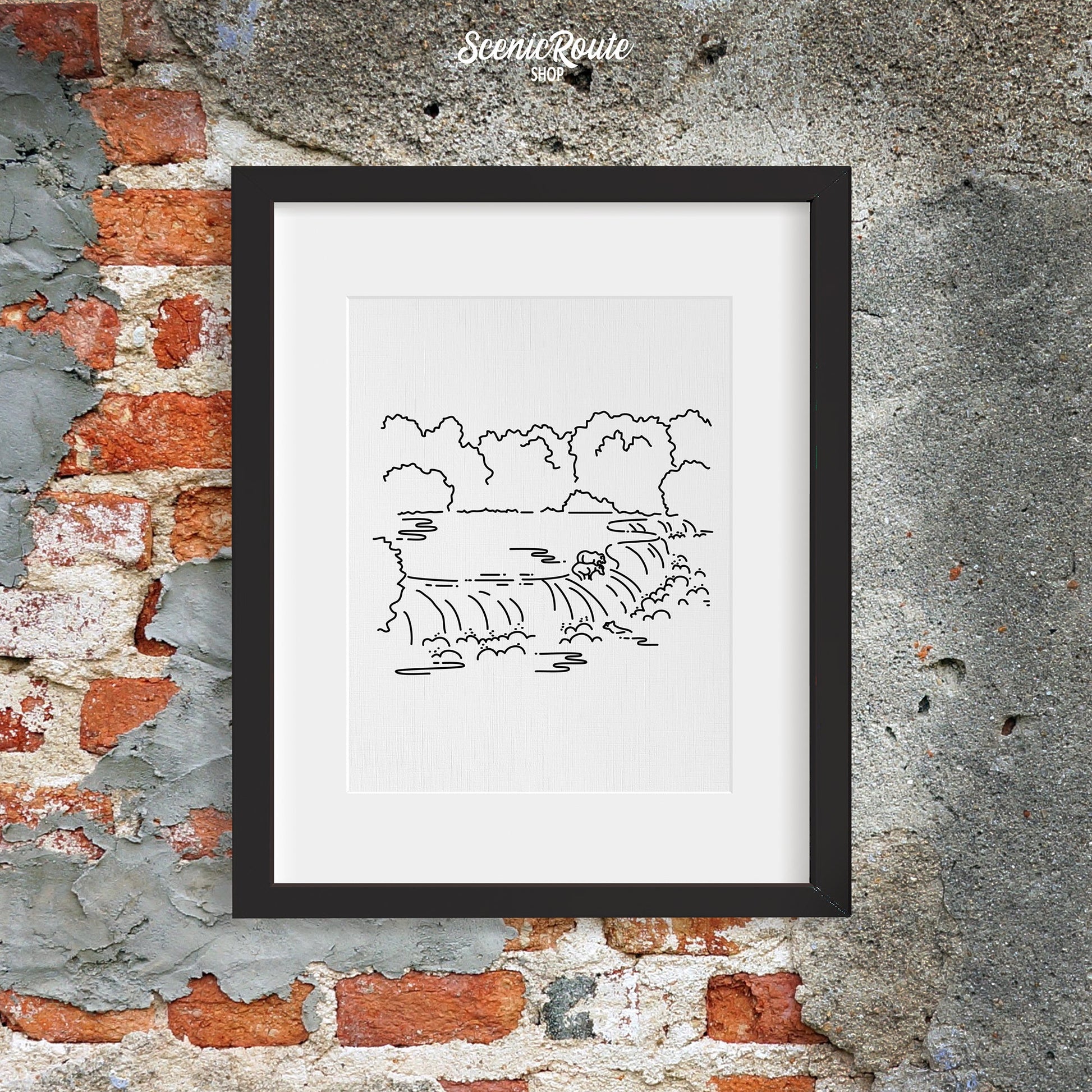 A framed line art drawing of Katmai National Park on a rough brick wall