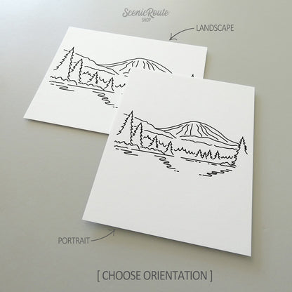 Two line art drawings of Lassen Volcanic National Park on white linen paper with a gray background.  The pieces are shown in portrait and landscape orientation for the available art print options.