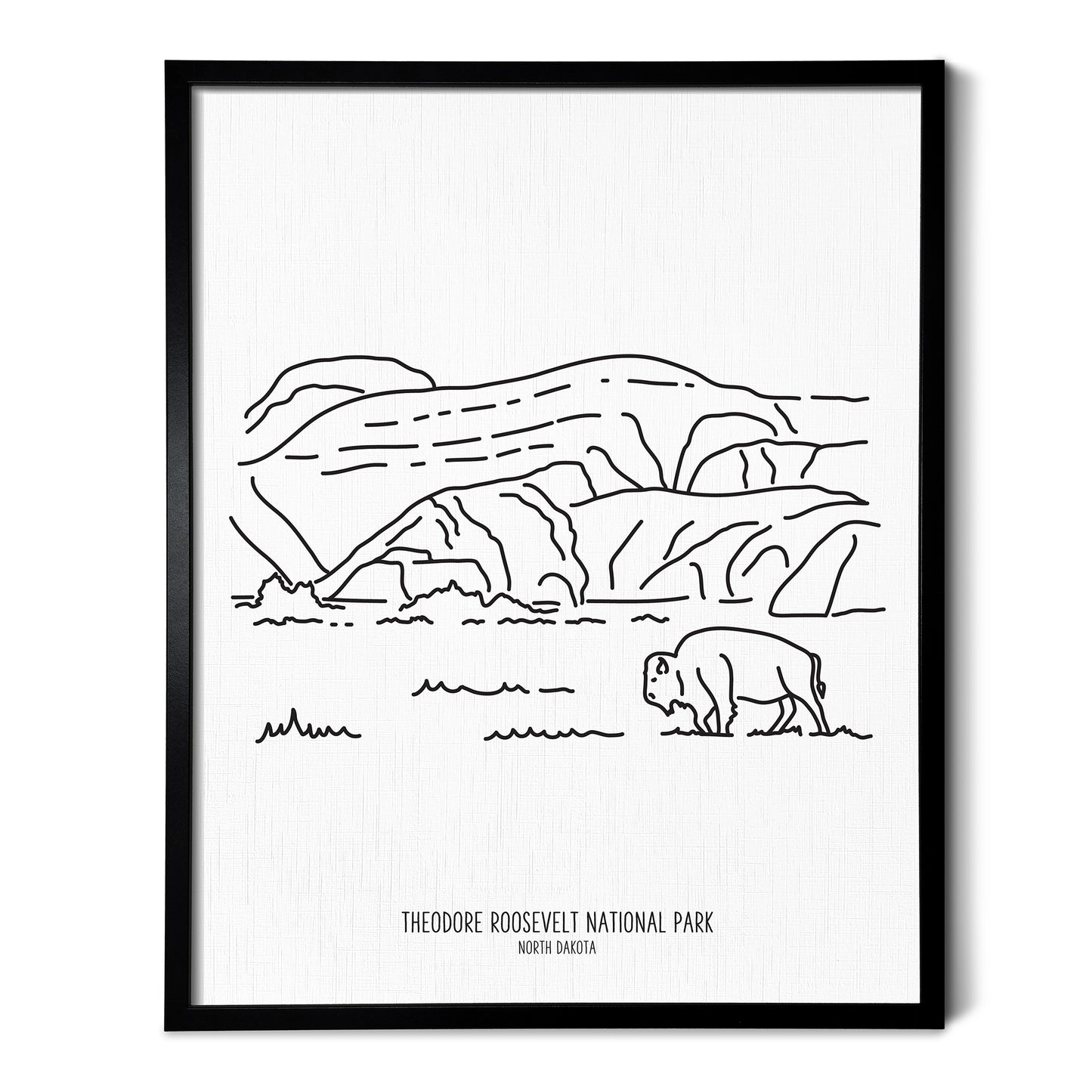A line art drawing of Theodore Roosevelt National Park on white linen paper in a thin black picture frame