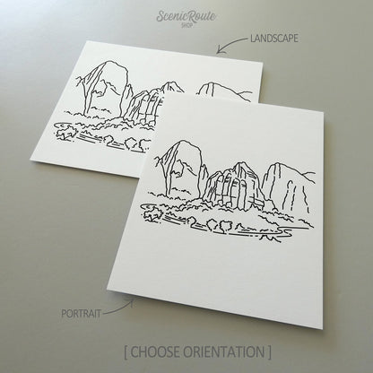 Two line art drawings of Zion National Park on white linen paper with a gray background.  The pieces are shown in portrait and landscape orientation for the available art print options.