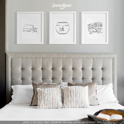 A group of three framed drawings on a white wall above a bed. The line art drawings include a Lighthouse, a Goldfish, and a Venice Gondola