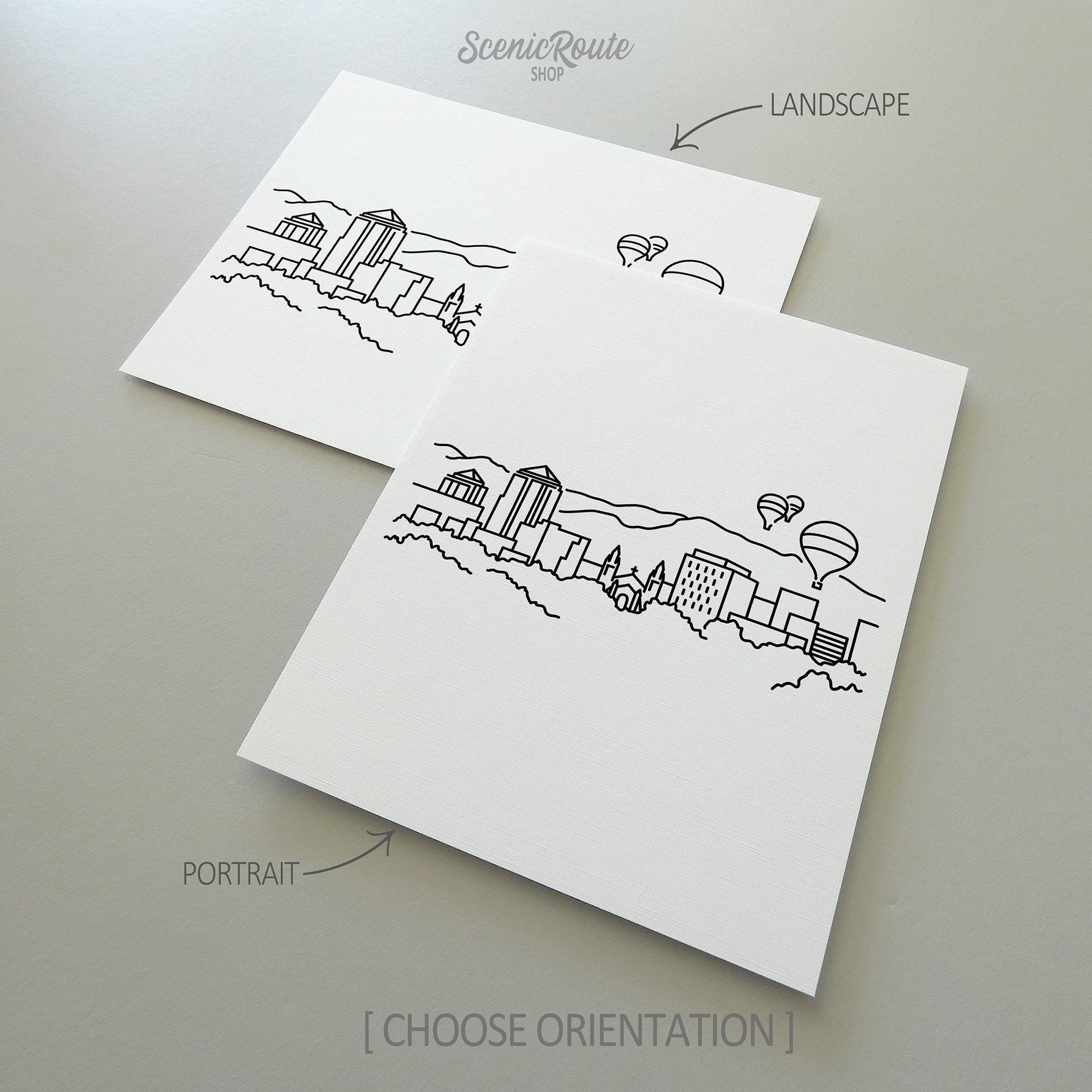 Two line art drawings of the Albuquerque Skyline on white linen paper with a gray background.  The pieces are shown in portrait and landscape orientation for the available art print options.
