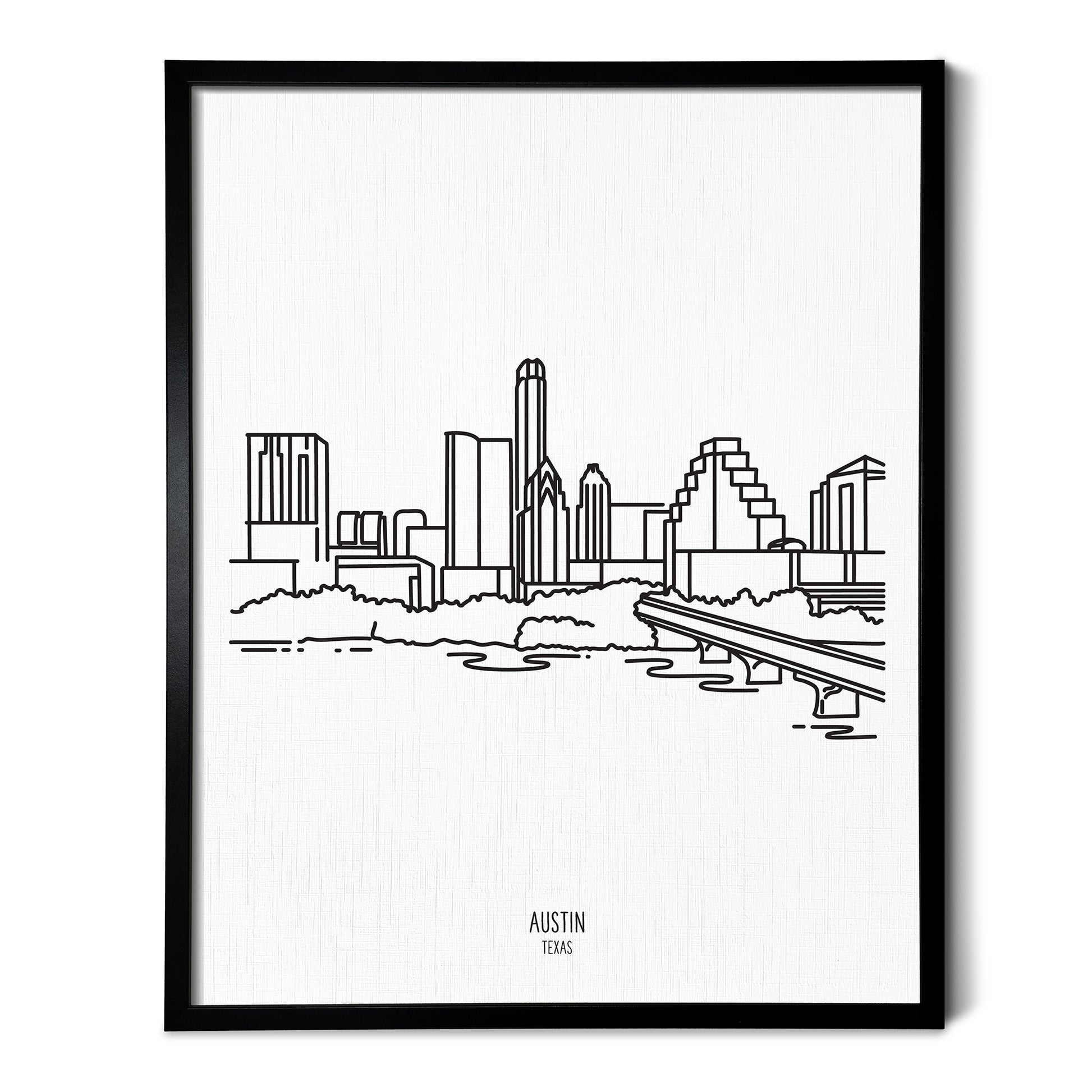 A line art drawing of the Austin Texas Skyline on white linen paper in a thin black picture frame
