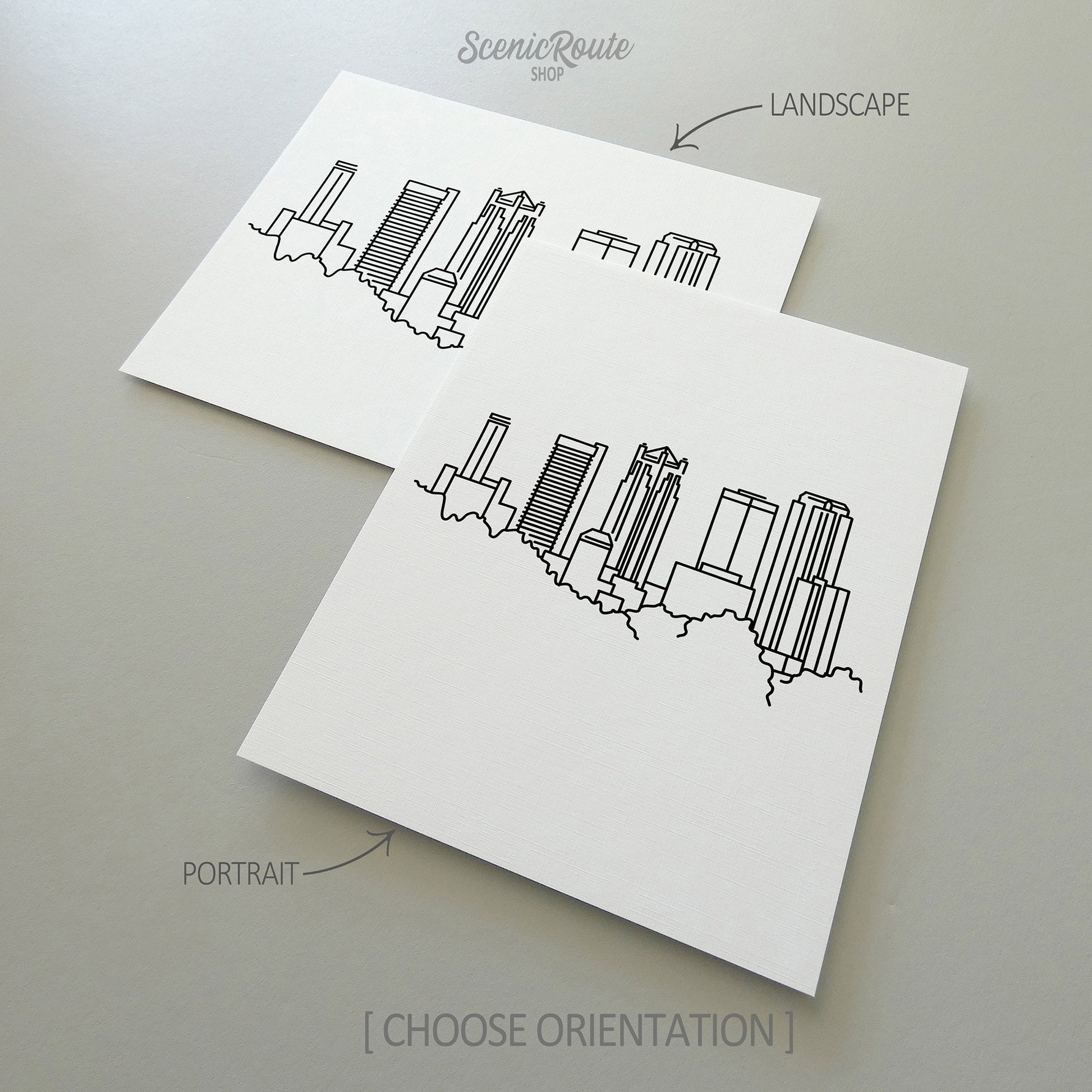 Two line art drawings of the Birmingham Skyline on white linen paper with a gray background.  The pieces are shown in portrait and landscape orientation for the available art print options.