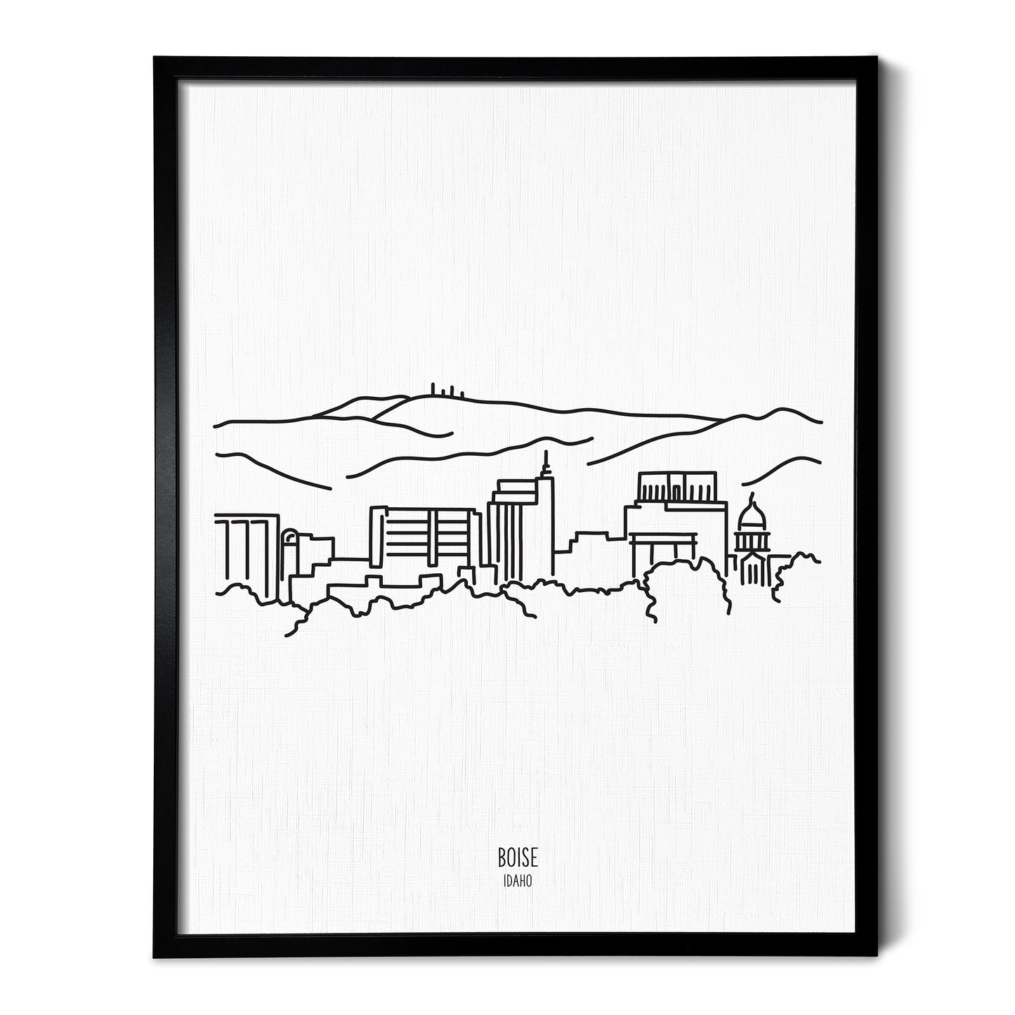 A line art drawing of the Boise Idaho Skyline on white linen paper in a thin black picture frame