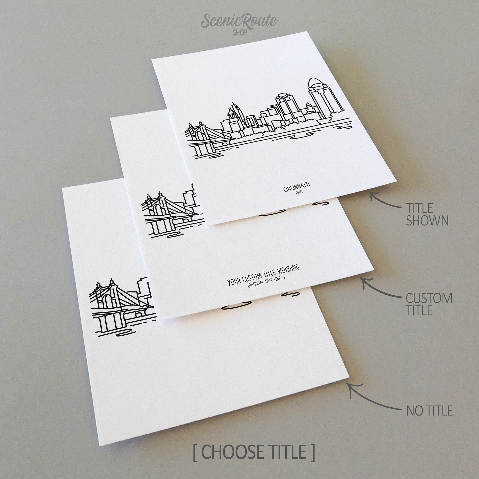 Three line art drawings of the Cincinnati Ohio Skyline on white linen paper with a gray background. The pieces are shown with title options that can be chosen and personalized.