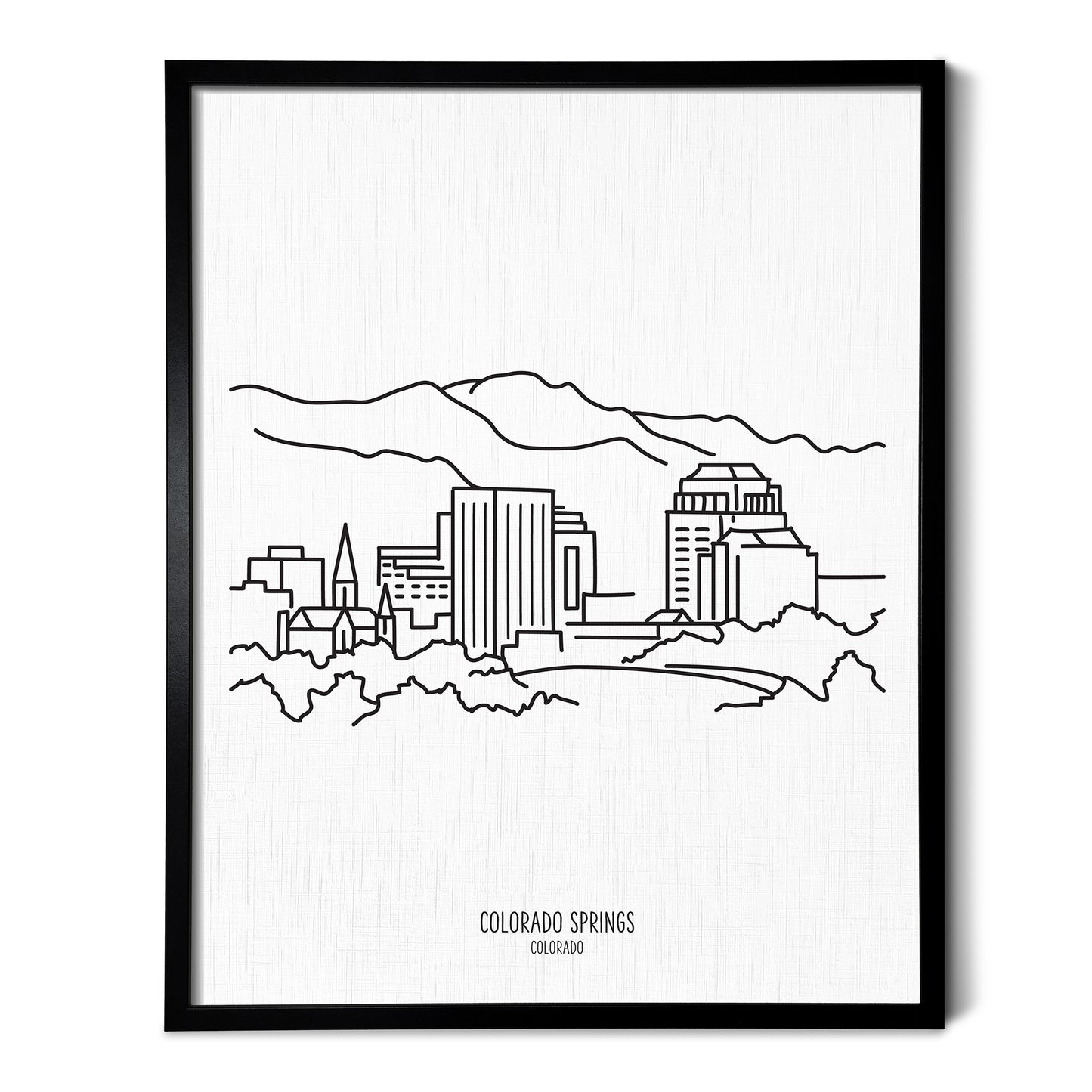 A line art drawing of the Colorado Springs Colorado Skyline on white linen paper in a thin black picture frame