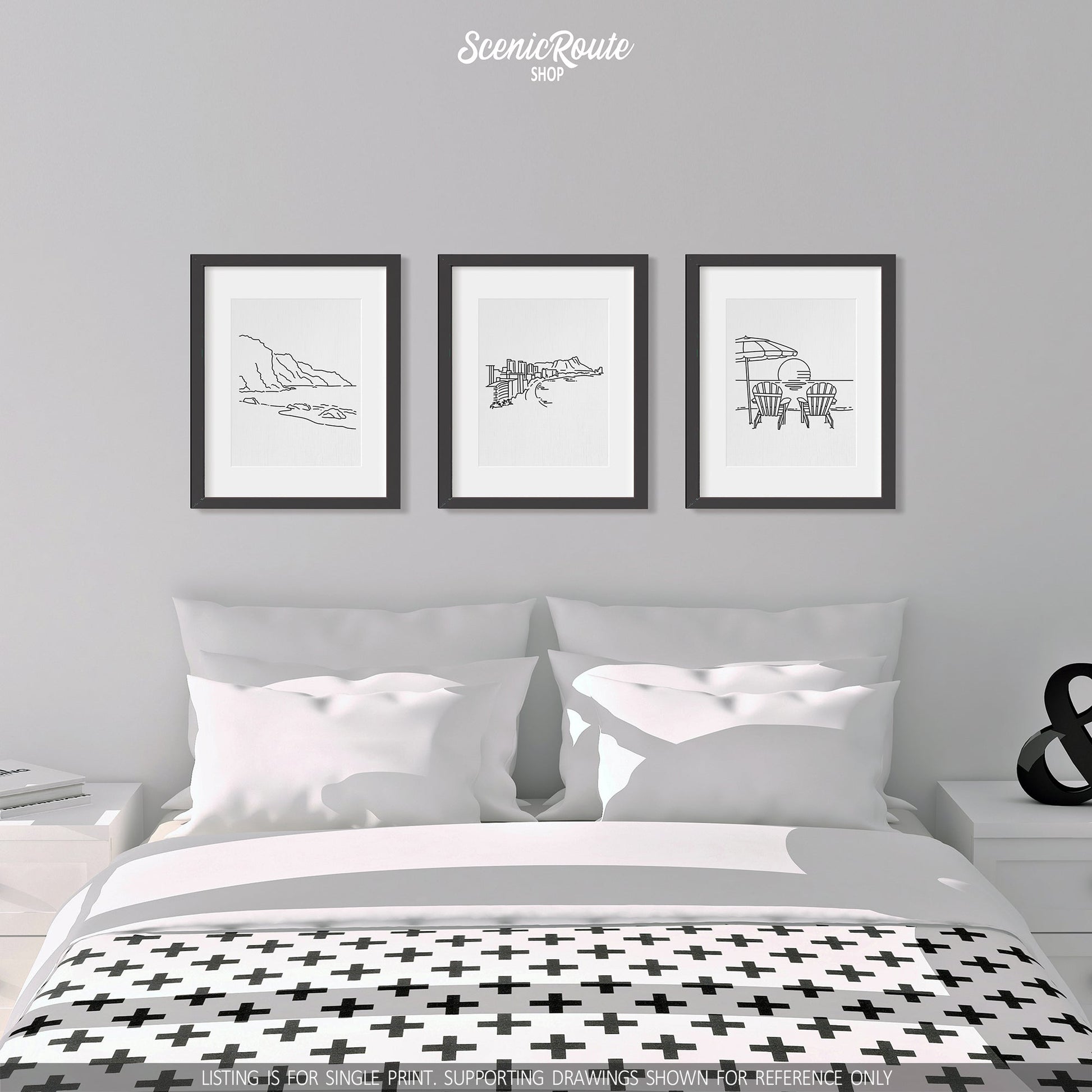 A group of three framed drawings on a white wall above a bed. The line art drawings include the NaPali Coast, Honolulu Skyline, and Adirondack Beach Chairs