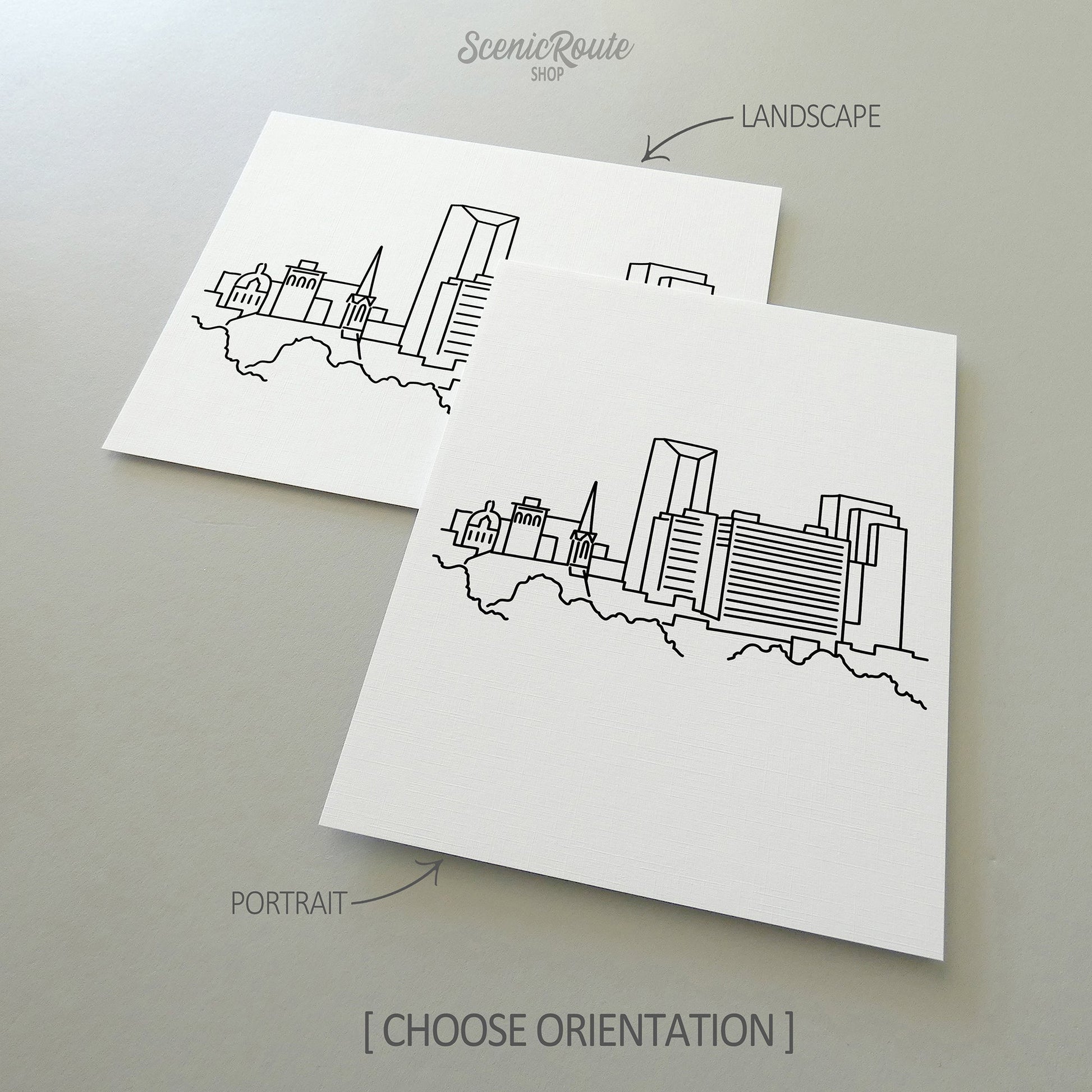 Two line art drawings of the Lexington Skyline on white linen paper with a gray background.  The pieces are shown in portrait and landscape orientation for the available art print options.