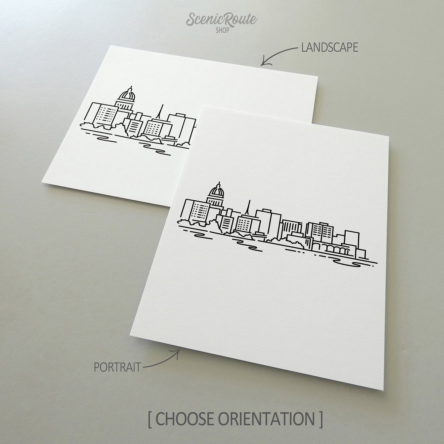 Two line art drawings of the Madison Skyline on white linen paper with a gray background.  The pieces are shown in portrait and landscape orientation for the available art print options.