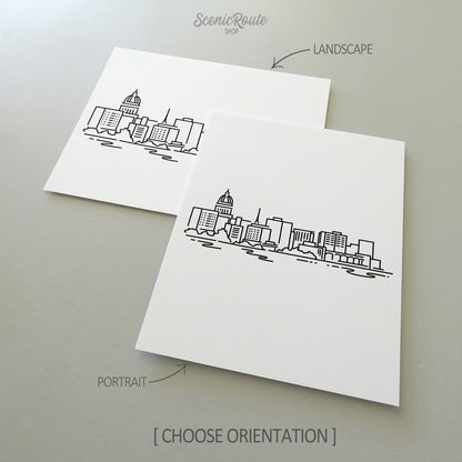 Two line art drawings of the Madison Skyline on white linen paper with a gray background.  The pieces are shown in portrait and landscape orientation for the available art print options.