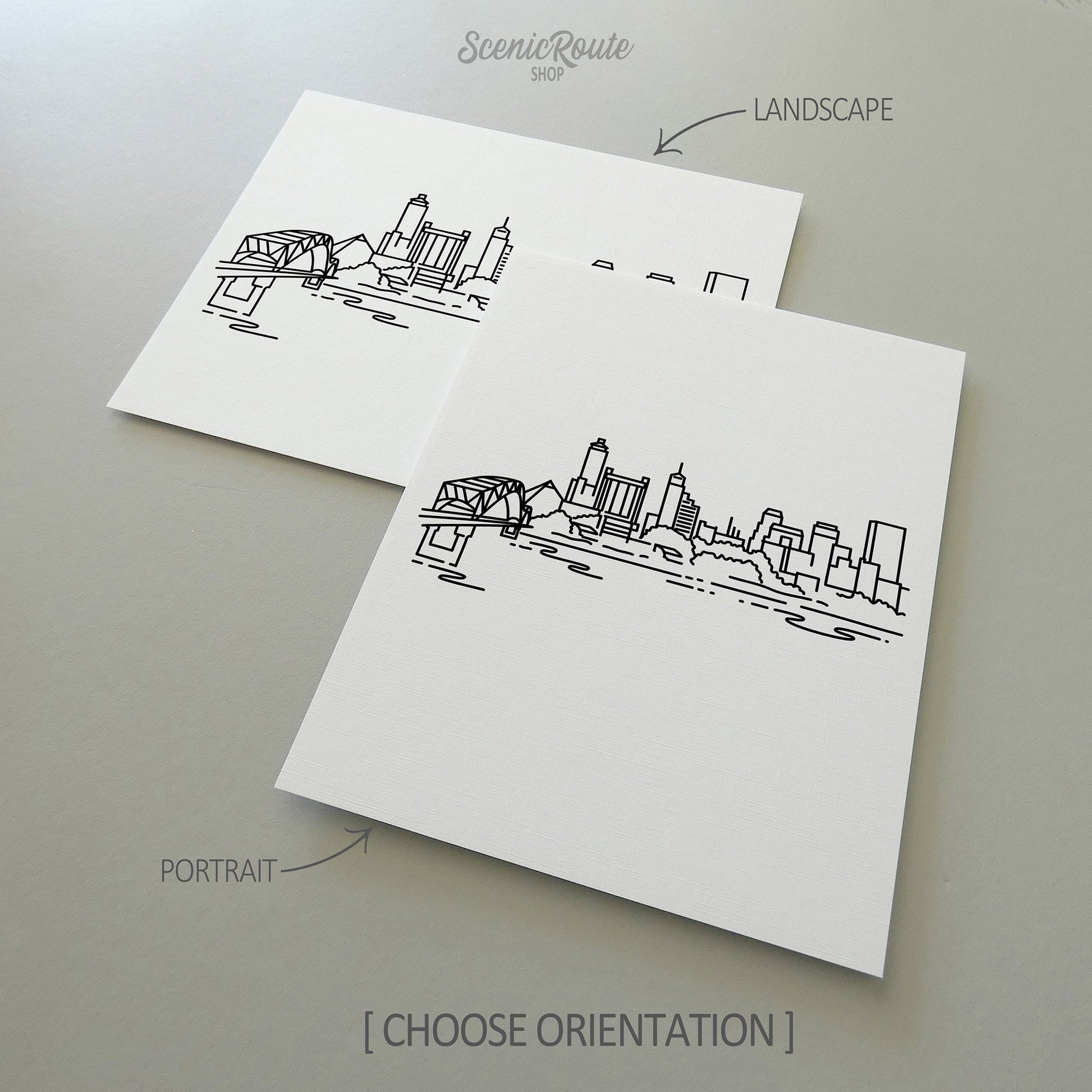 Two line art drawings of the Memphis Skyline on white linen paper with a gray background.  The pieces are shown in portrait and landscape orientation for the available art print options.