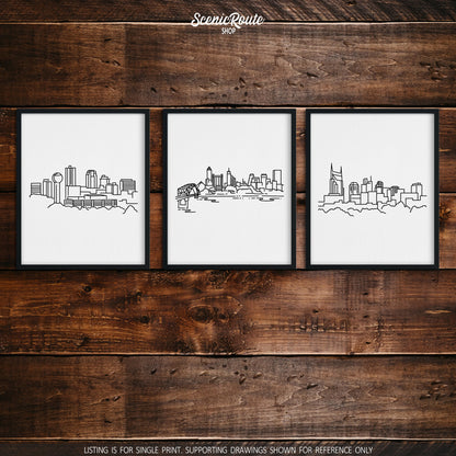 A group of three framed drawings on a wood wall. The line art drawings include the Knoxville Skyline, Memphis Skyline, and Nashville Skyline