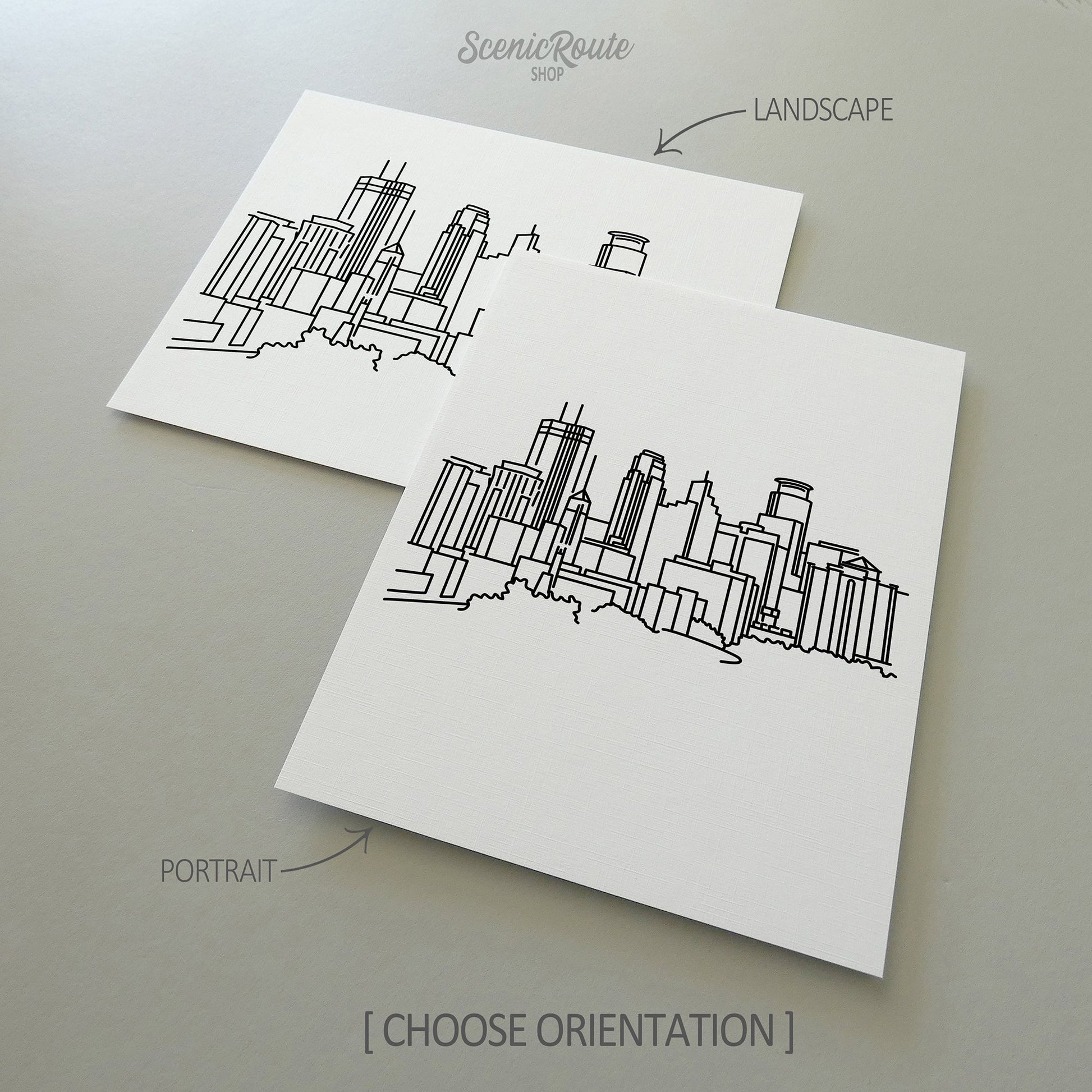 Two line art drawings of the Minneapolis Skyline on white linen paper with a gray background.  The pieces are shown in portrait and landscape orientation for the available art print options.