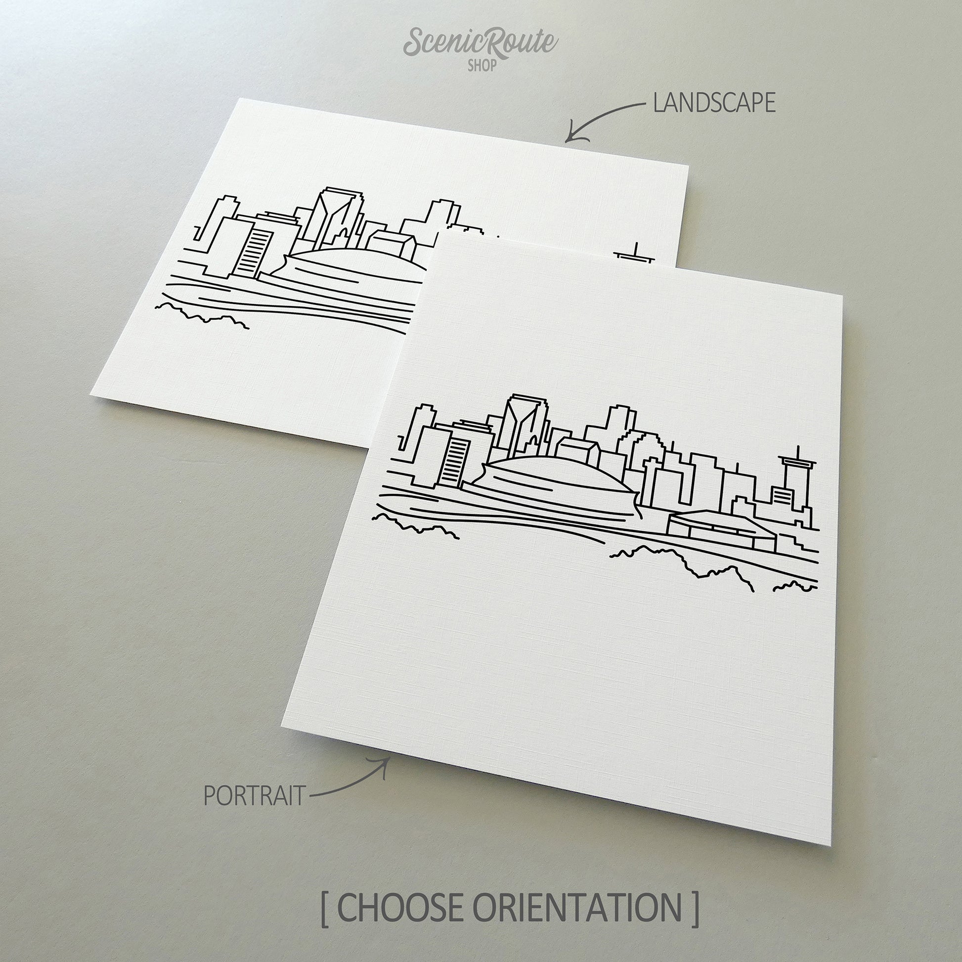 Two line art drawings of the New Orleans Skyline on white linen paper with a gray background.  The pieces are shown in portrait and landscape orientation for the available art print options.