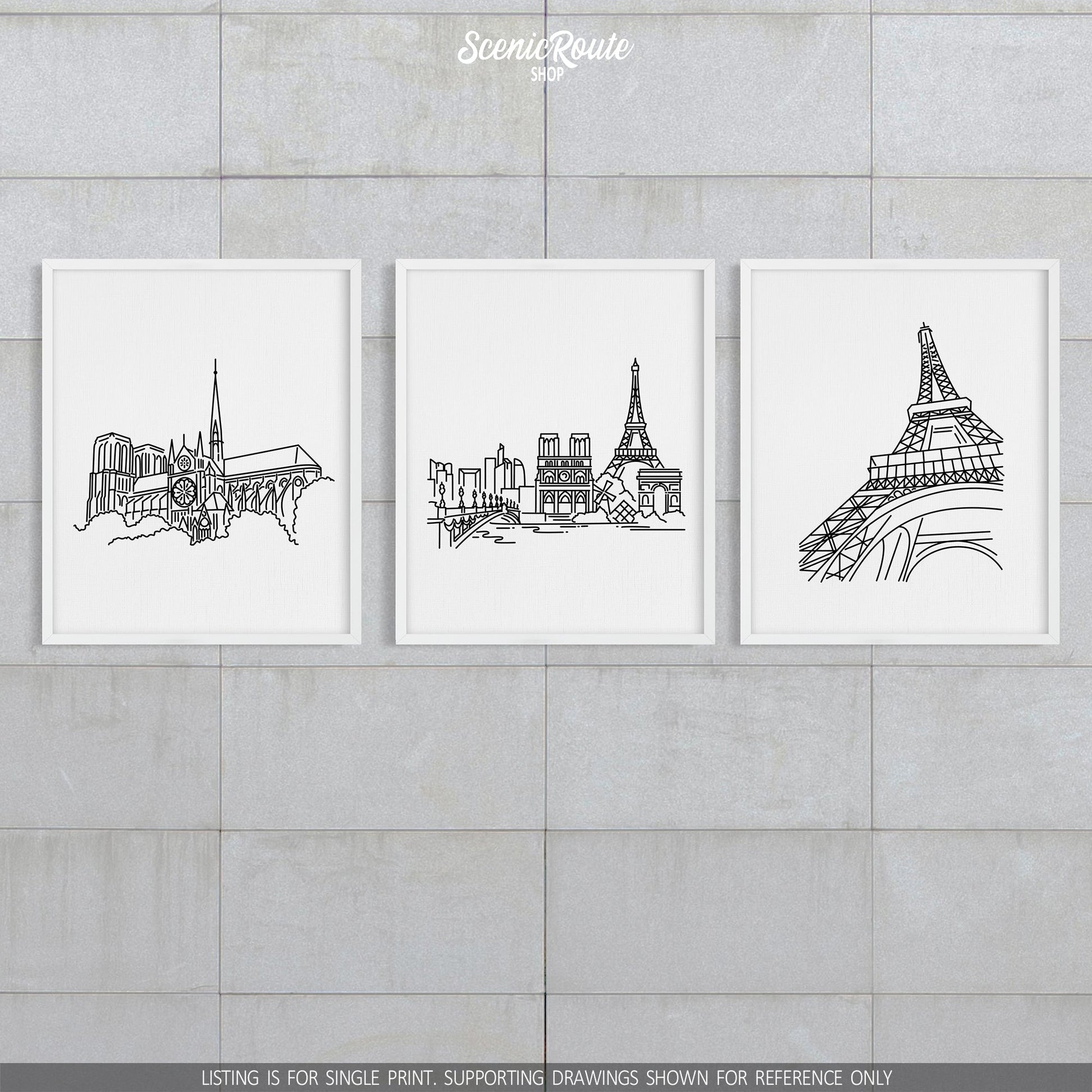 A group of three framed drawings on a block wall. The line art drawings include the Notre Dame Cathedral, Paris Skyline, and Eiffel Tower
