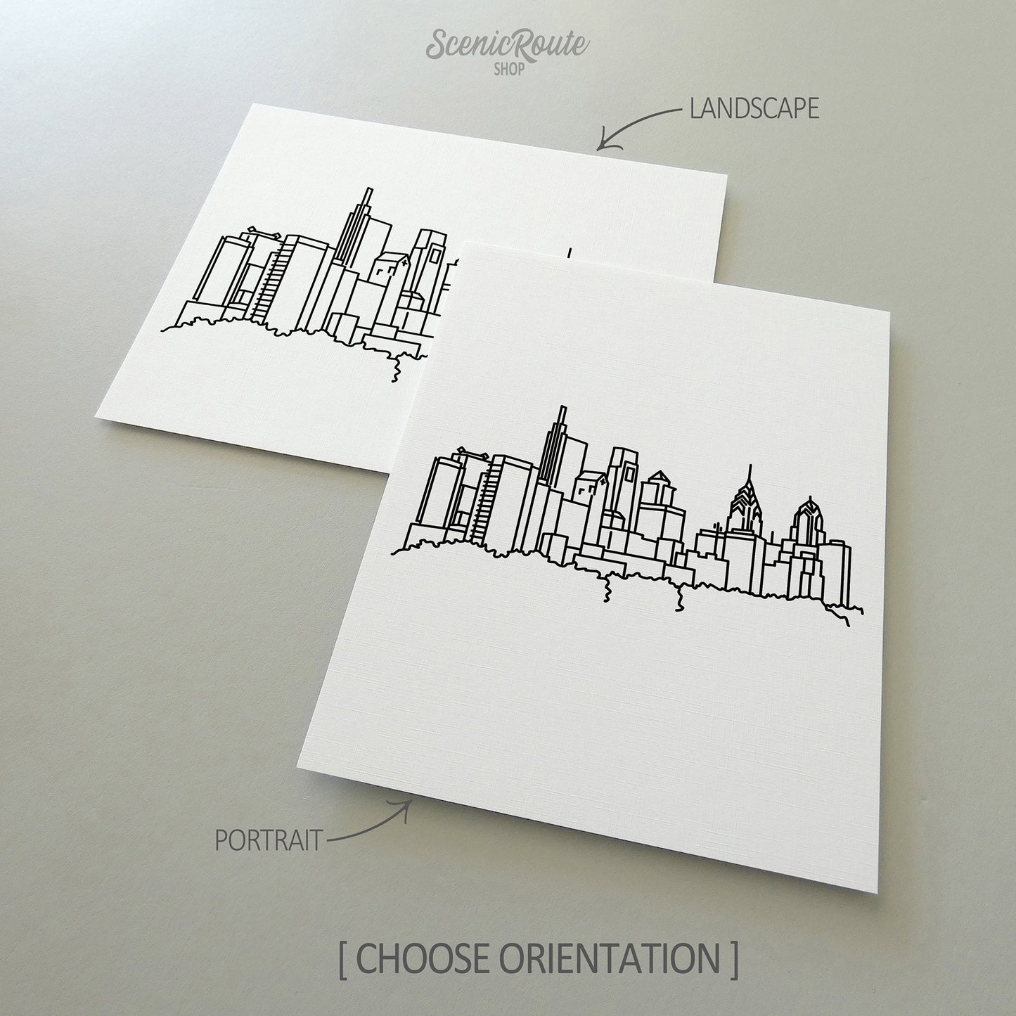 Two line art drawings of the Philadelphia Skyline on white linen paper with a gray background.  The pieces are shown in portrait and landscape orientation for the available art print options.