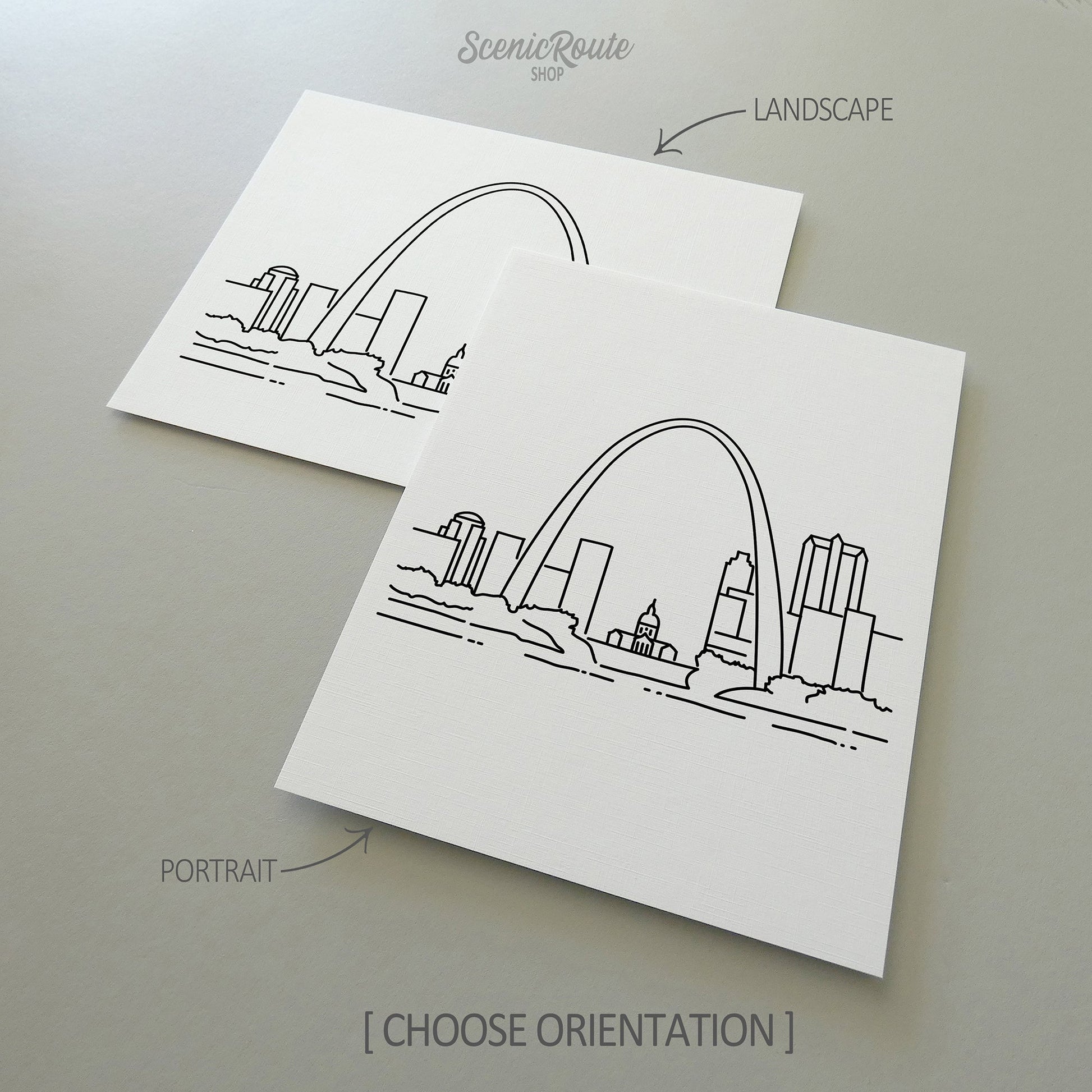 Two line art drawings of the Saint Louis Skyline on white linen paper with a gray background.  The pieces are shown in portrait and landscape orientation for the available art print options.