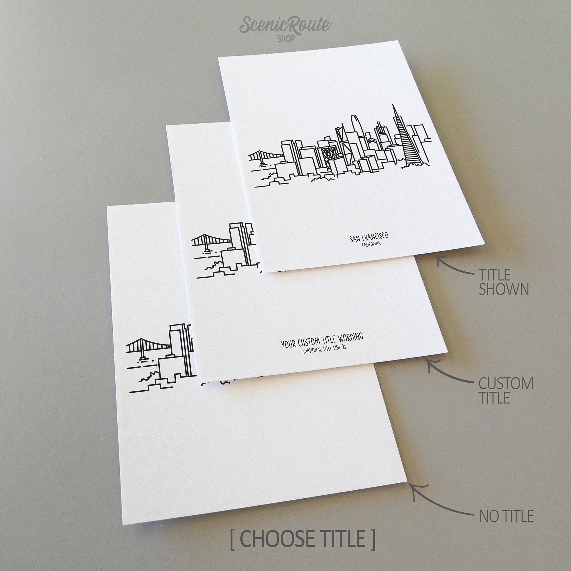 Three line art drawings of the San Francisco California Skyline on white linen paper with a gray background. The pieces are shown with title options that can be chosen and personalized.