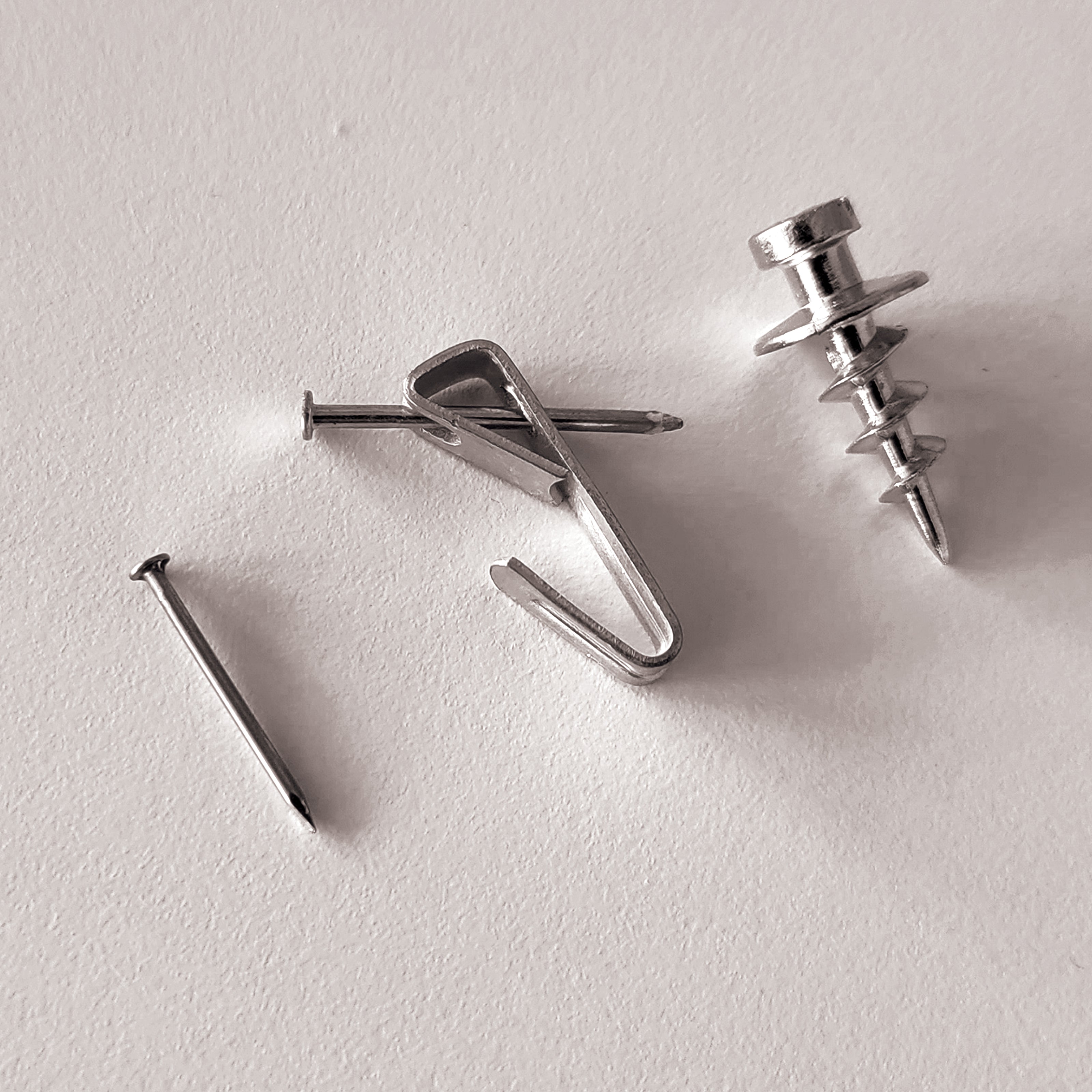 a nail, a picture hanger, and a self-drilling screw hardware