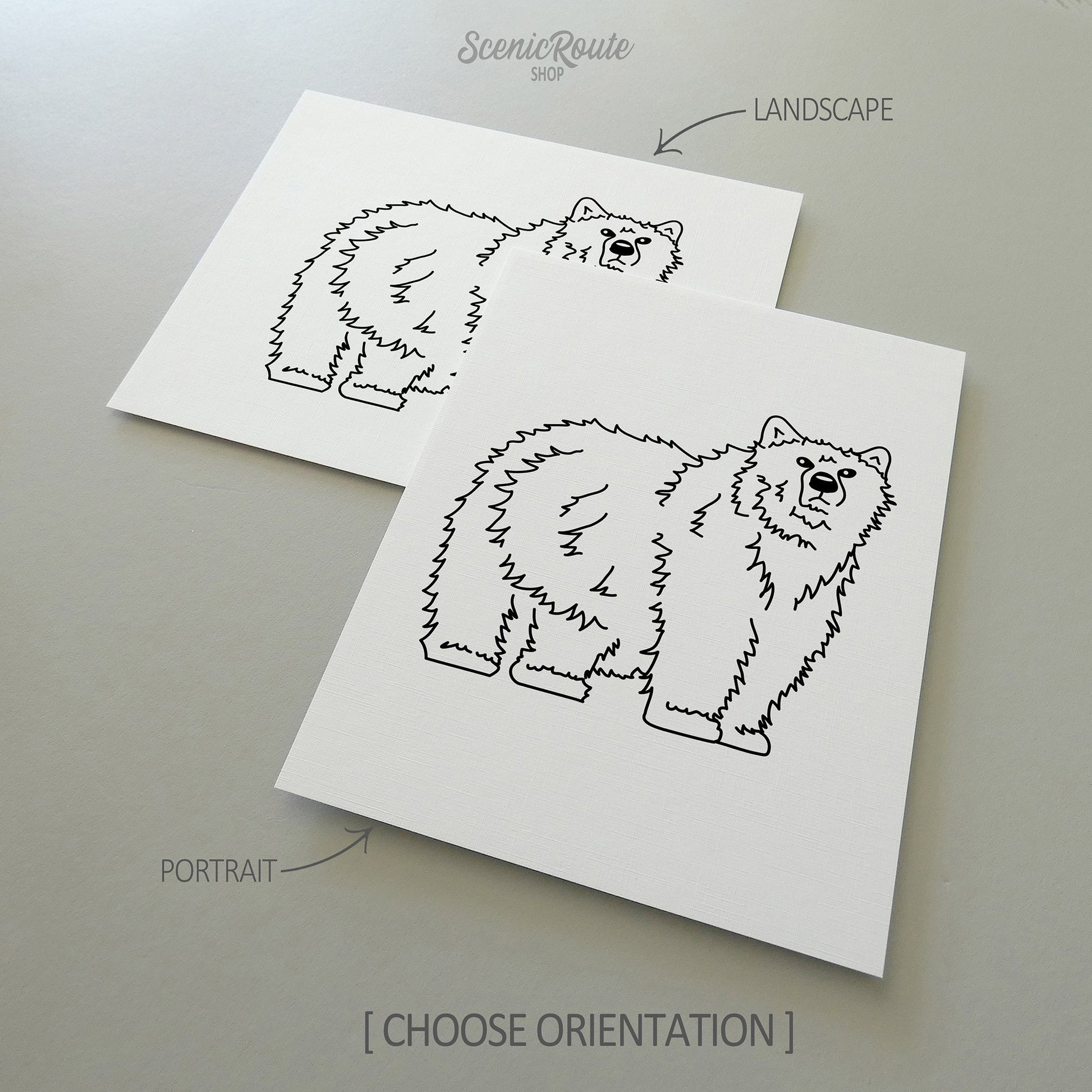 Two line art drawings of a Grizzly Bear on white linen paper with a gray background.  The pieces are shown in portrait and landscape orientation for the available art print options.